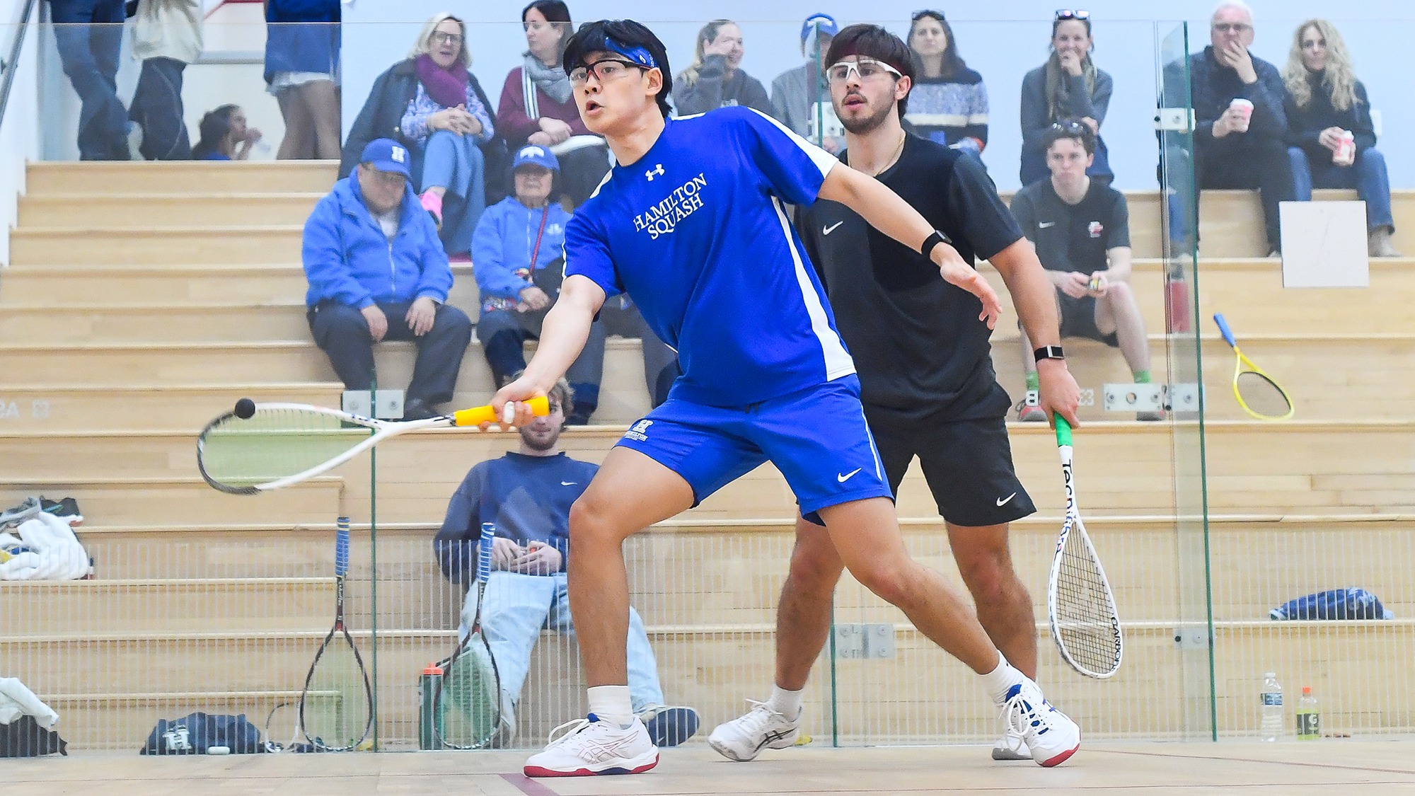 Jacob Li hits a forehand shot in his squash match against Denison