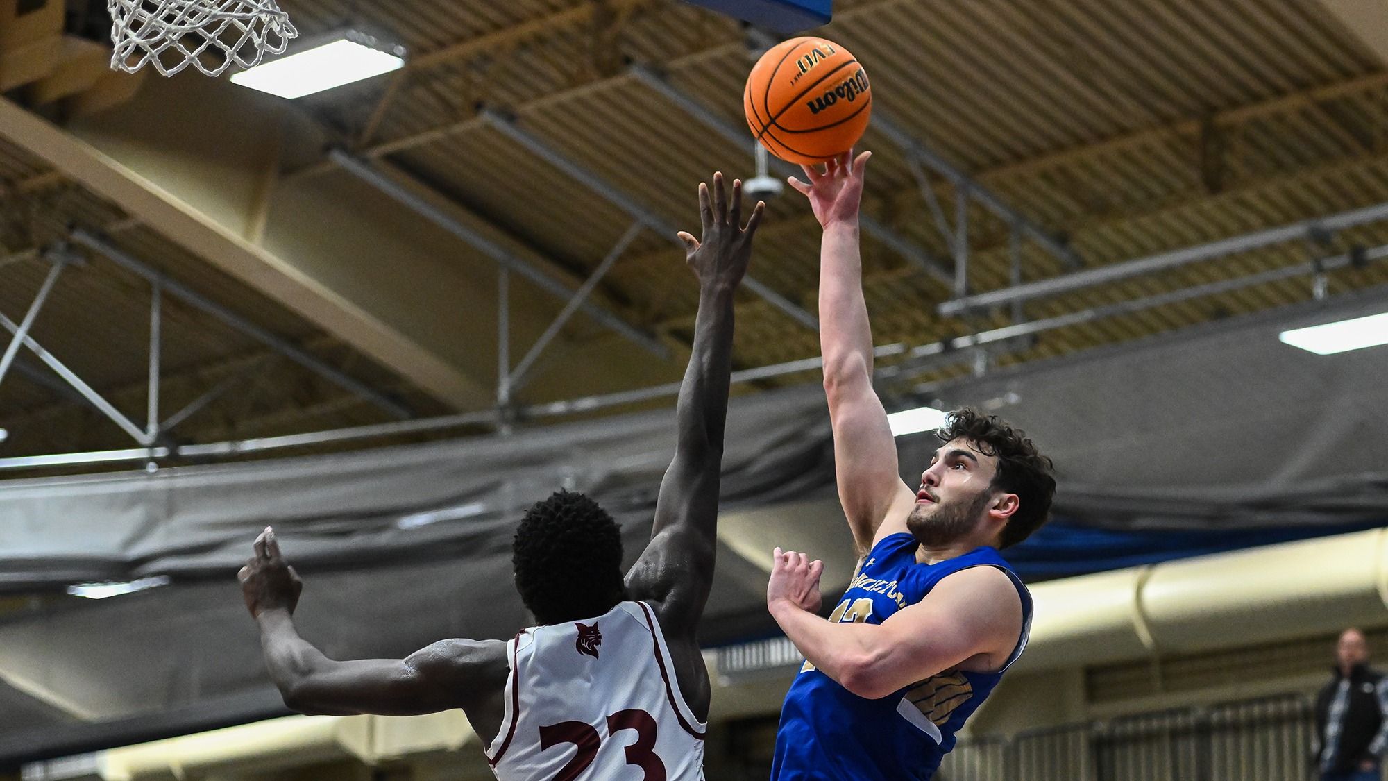 Garret Keyhani shoots a right-handed hook shot over a Bates defender's hand