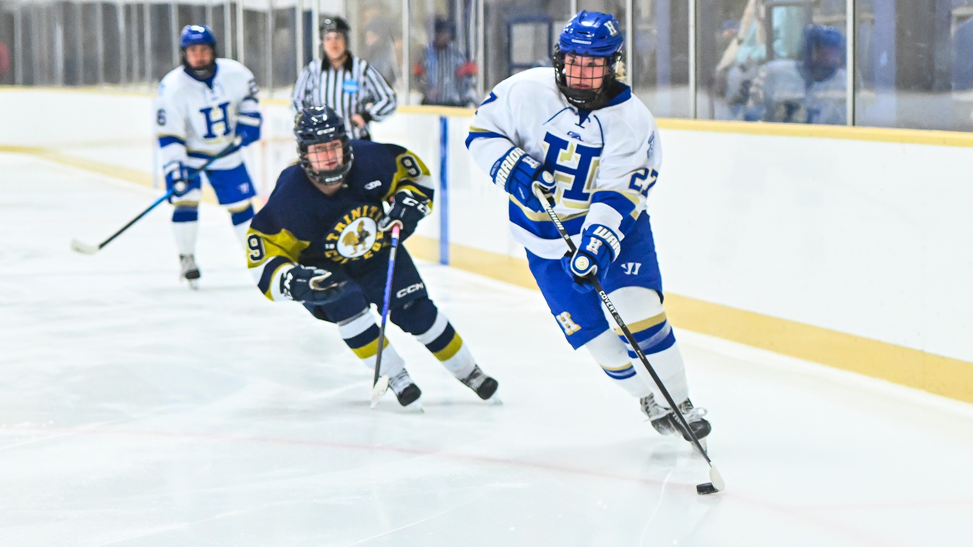 Sarah Wagner carries the puck into the left faceoff circle in Trinity's defensive zone