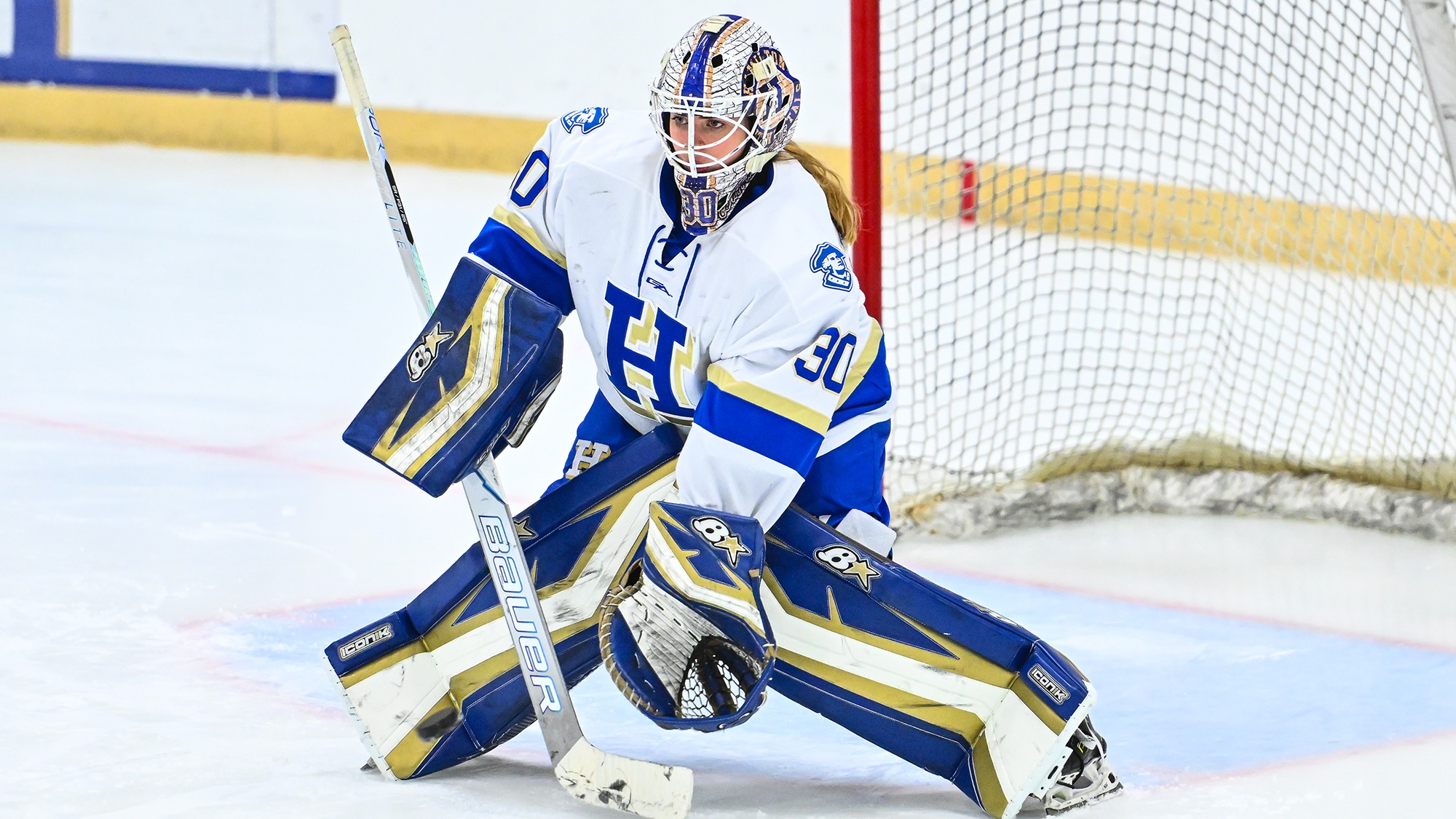 Goaltender Teagan Brown reaches down low to grab the puck during warmups before playing Trinity in November 2025