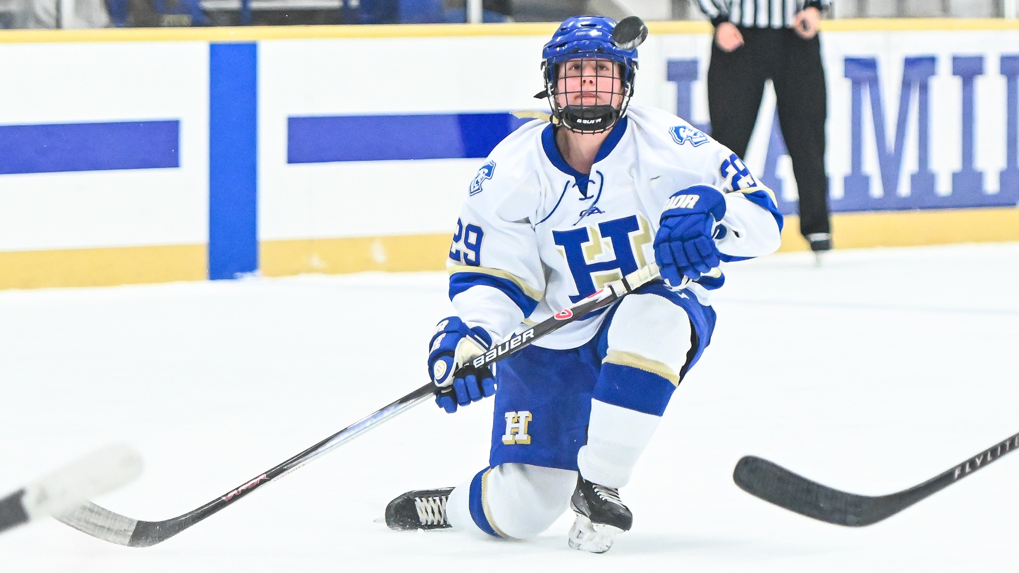 Sophia Testa goes down to one knee and watches the hockey puck as it pops up into the air in front of her face