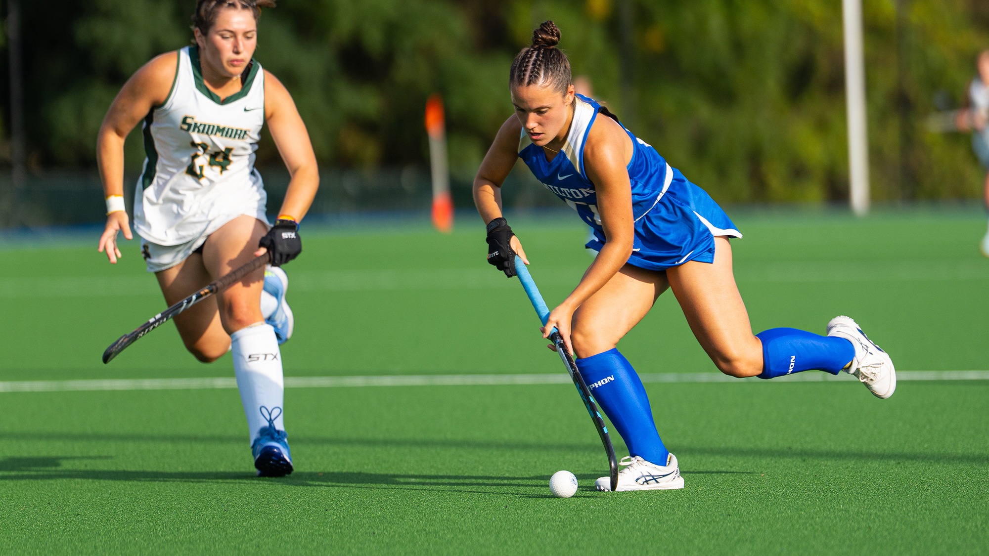 Brighton McMahon stickhandles past a Skidmore field hockey defender