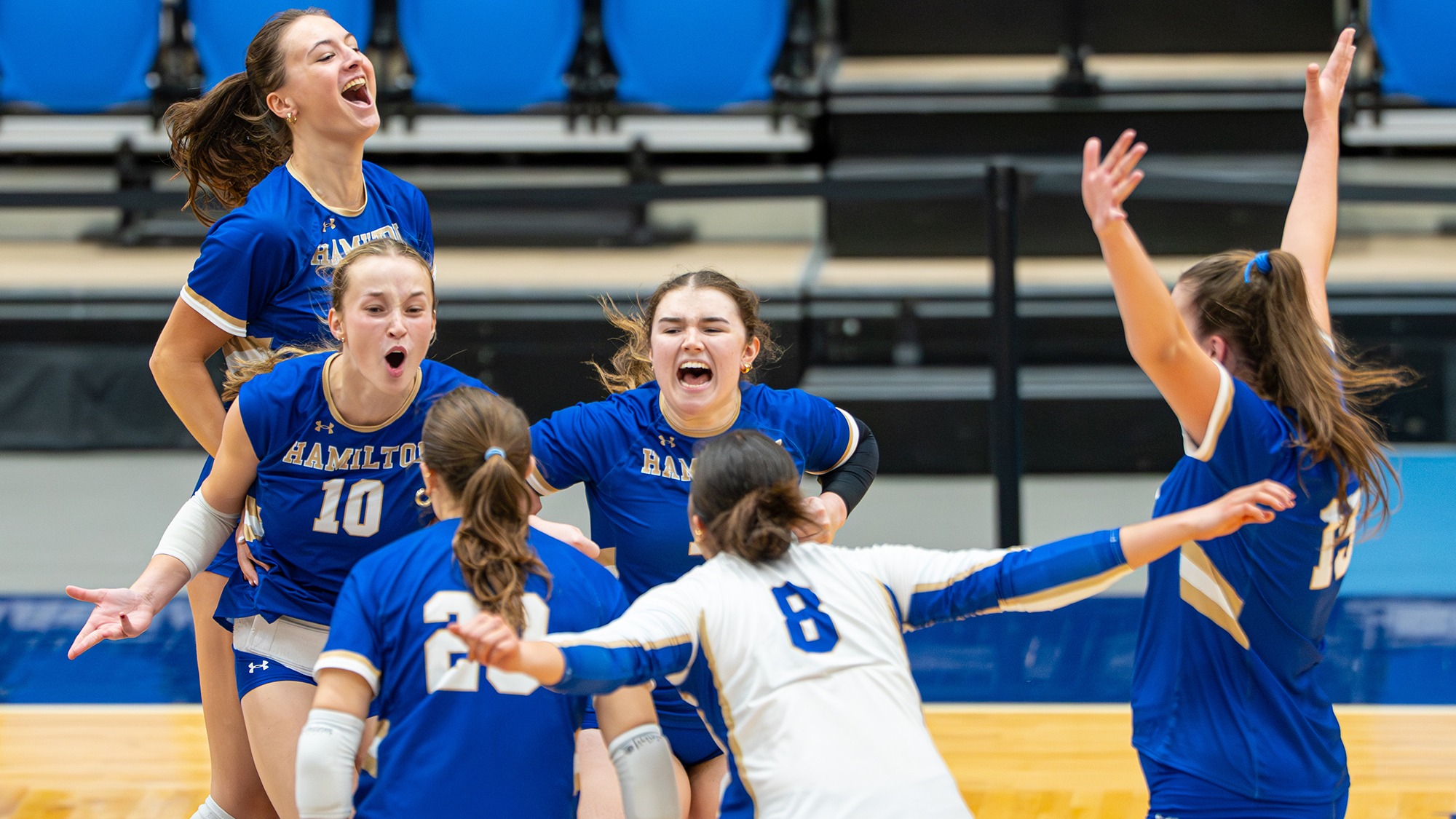 Volleyball players celebrate a point in the Bates match