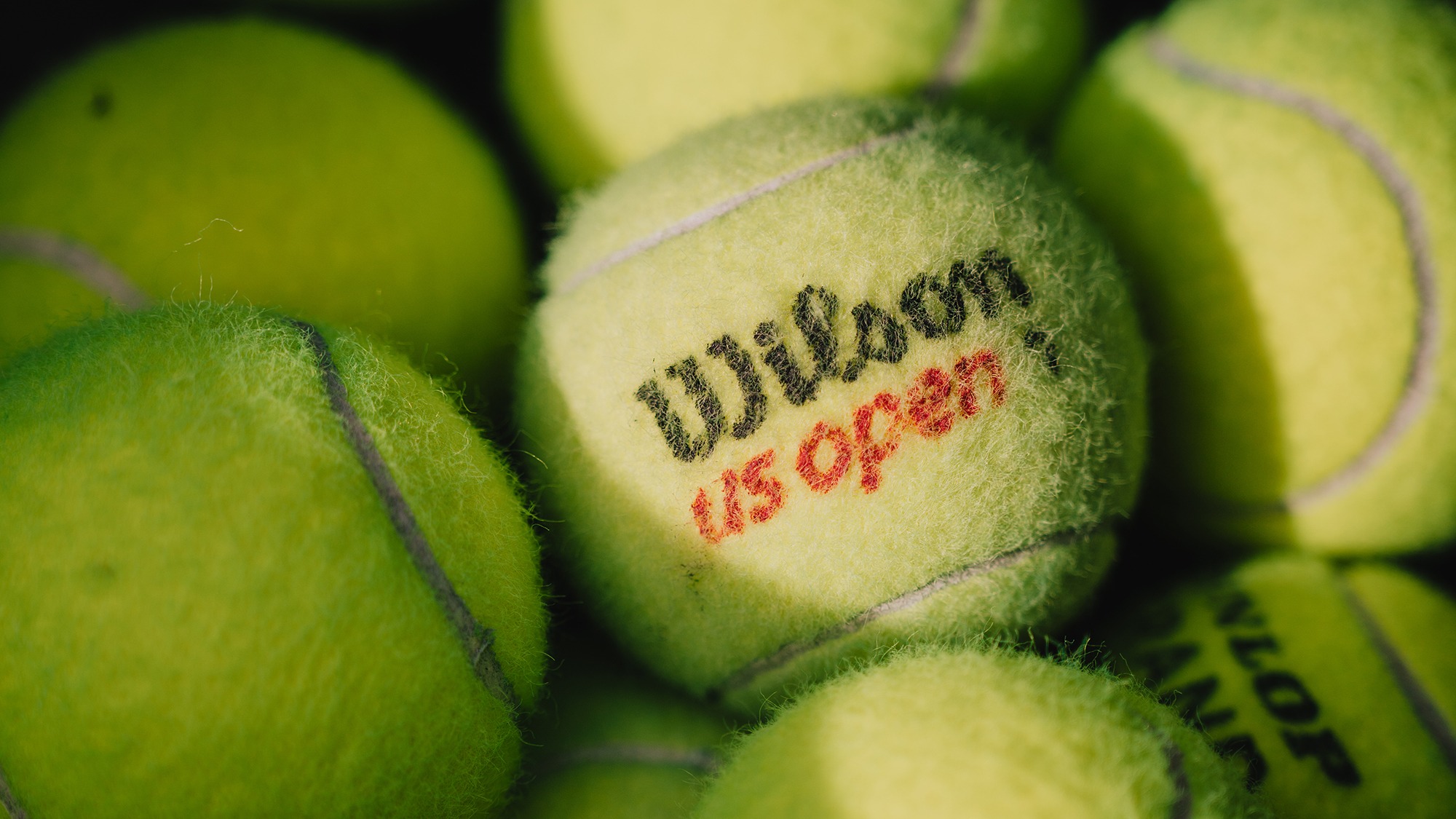 Tennis balls sit in a cart during a women's match against Union