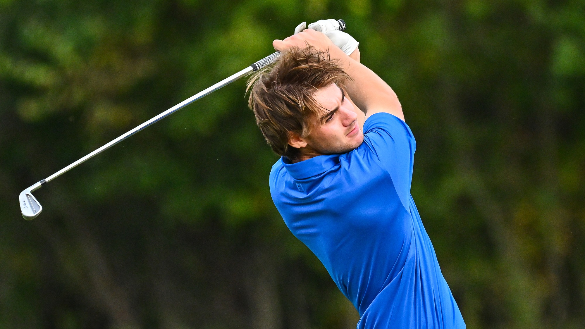 Gunnar Moore hits an iron on the driving range at golf practice in September 2025