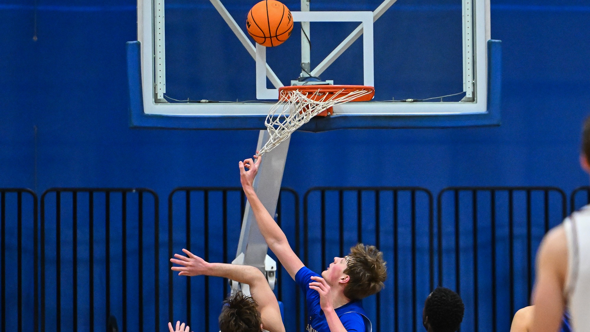 A Hamilton Men's Basketball gets his finger caught in the net as the ball bounces off the backboard against Bates