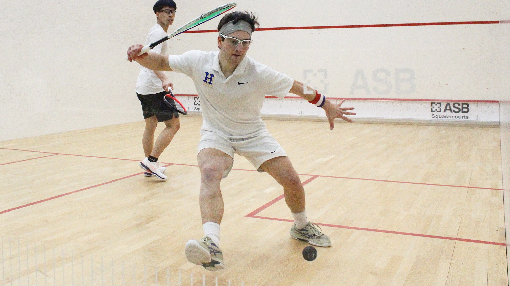 Jacob Shulman hits the squash ball near the back wall in the NESCAC championship quarterfinal