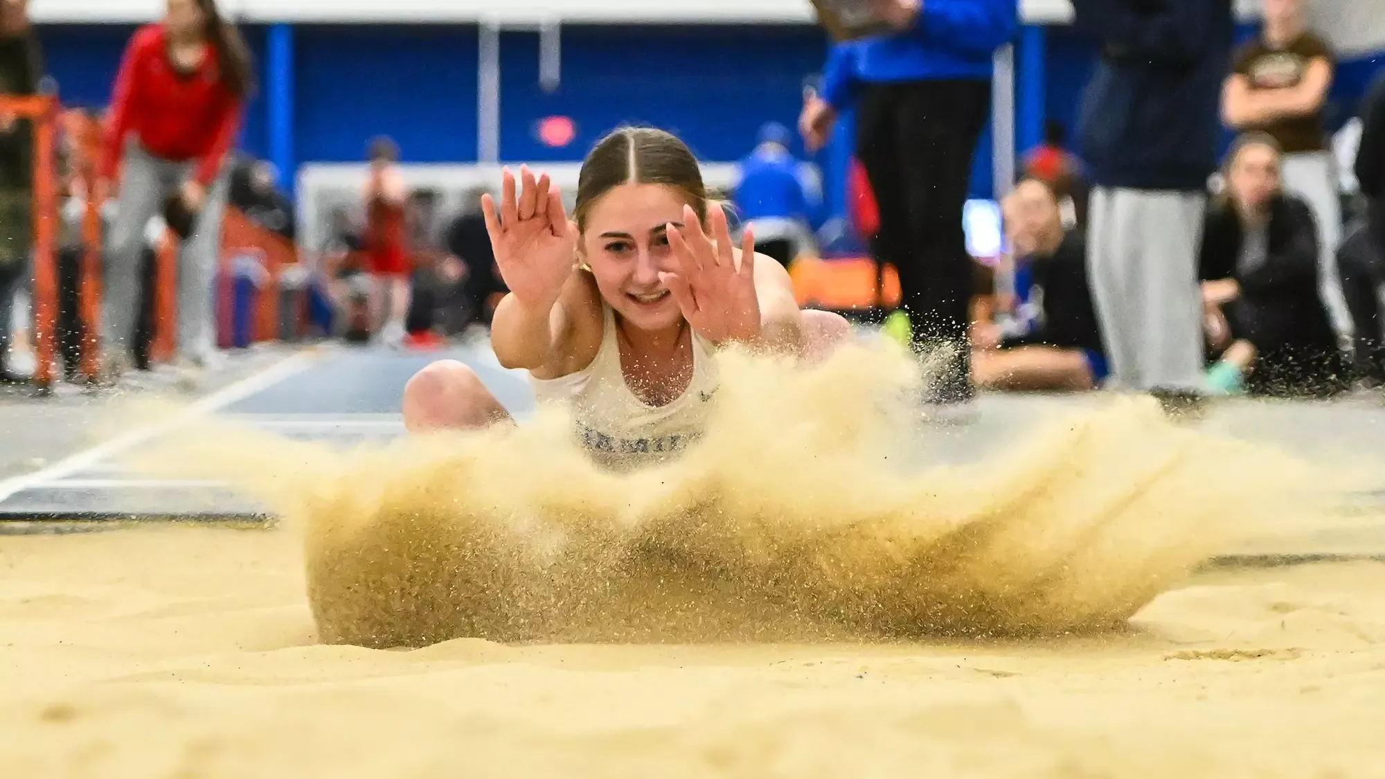Mackenzie Loudon lands in the sand in the jumping pit doing the triple jump at the Utica Winter Opener