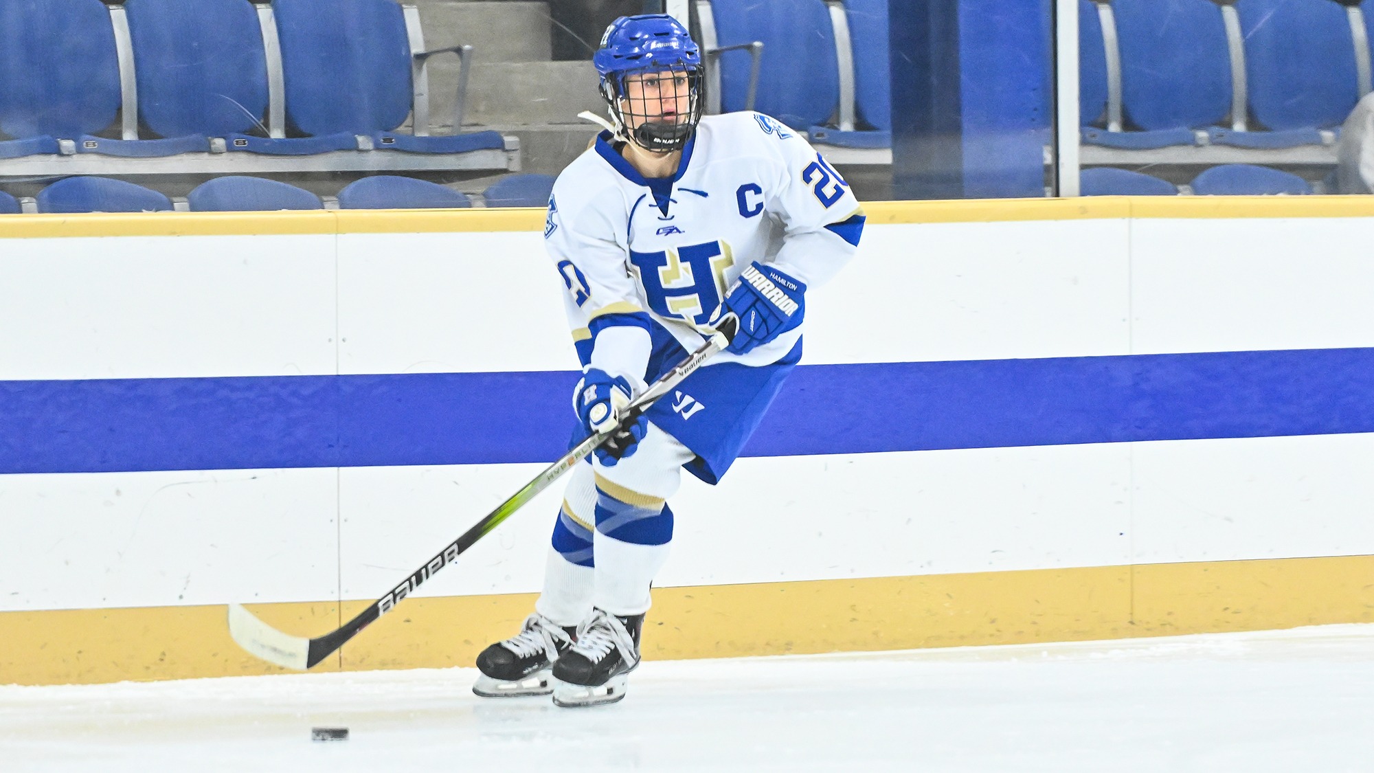 Lilly Truchon looks up to find a teammate to pass the puck to in a women's hockey win over SUNY Canton