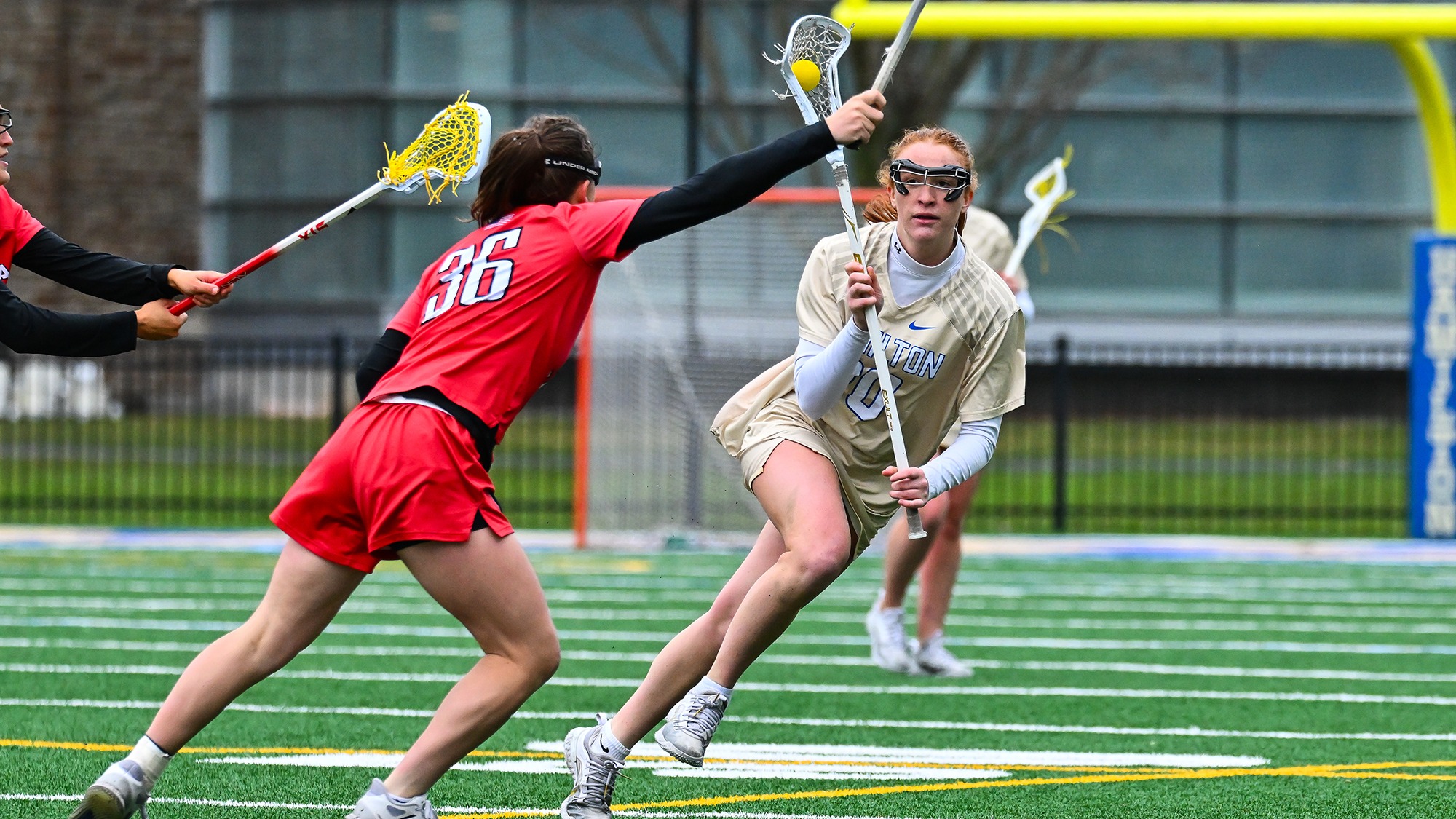 Claire Neumann brings the ball up the lacrosse field on a clear attempt against Wesleyan