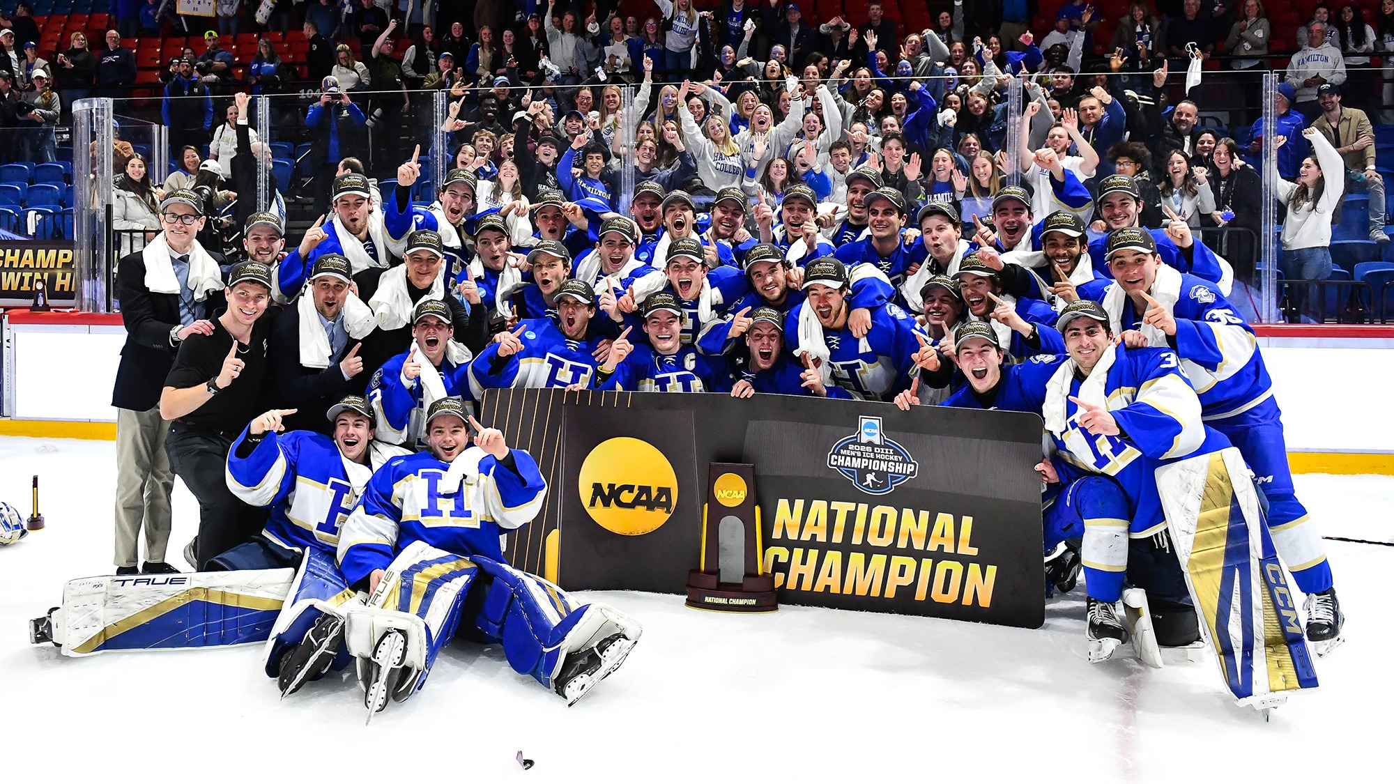 Men's Hockey team poses with the NCAA champions banner after defeating Hobart in the 2026 national final