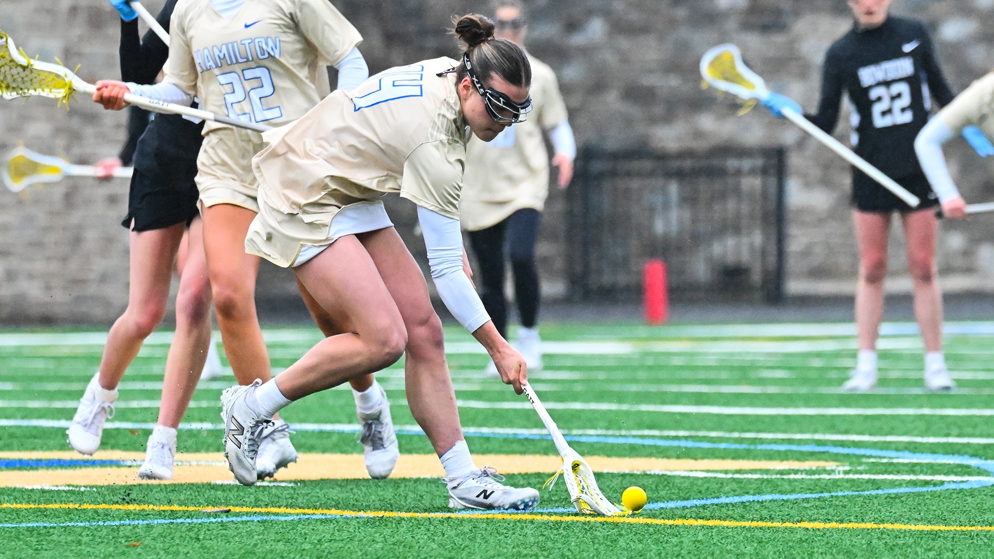 Kristin Vosswinkel picks up a loose ball for a draw control win in a women's lacrosse game against Bowdoin