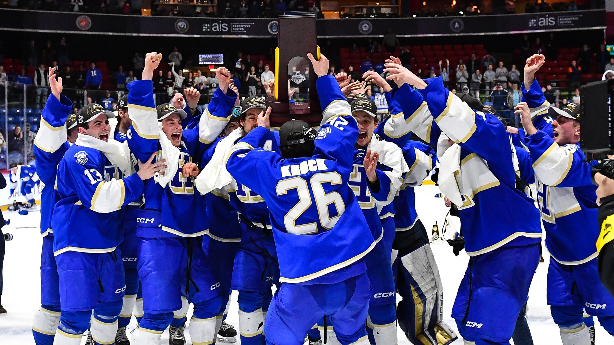 Men's Hockey players celebrate with the NCAA champion trophy after defeating Hobart in the final