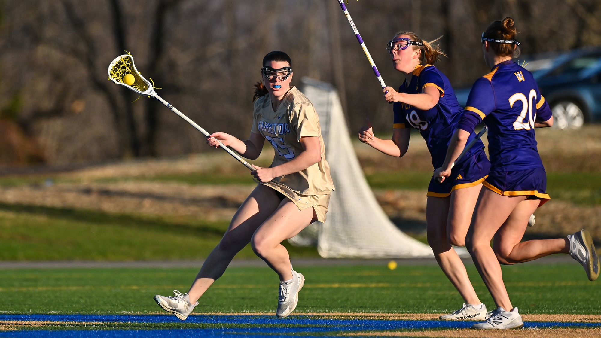 Grace Martucci avoids two Williams women's lacrosse defenders while bringing the ball up on a clear attempt