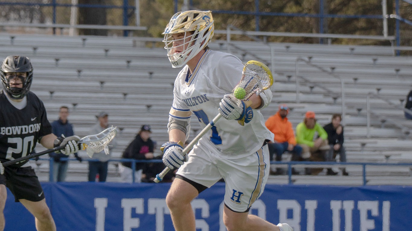 Maddux Little makes a move in the attack area in a men's lacrosse game against Bowdoin