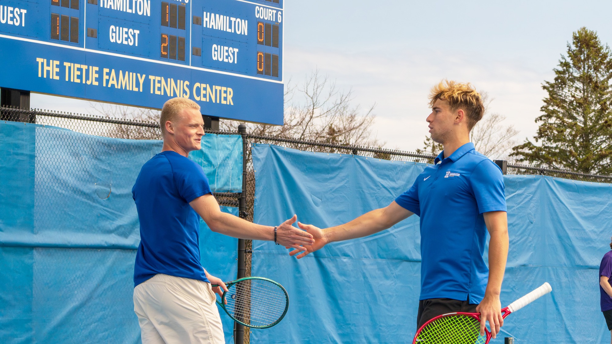 Men's Tennis players Alexei Katelevsky and Filip Moller high five each other after a doubles point against Amherst