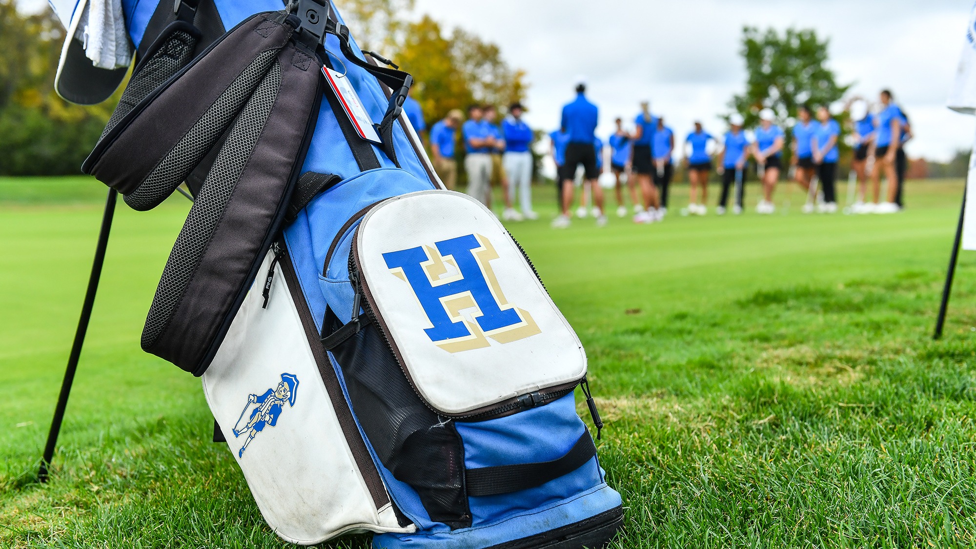 A Hamilton golf bag sits by the putting green before practice in September 2025