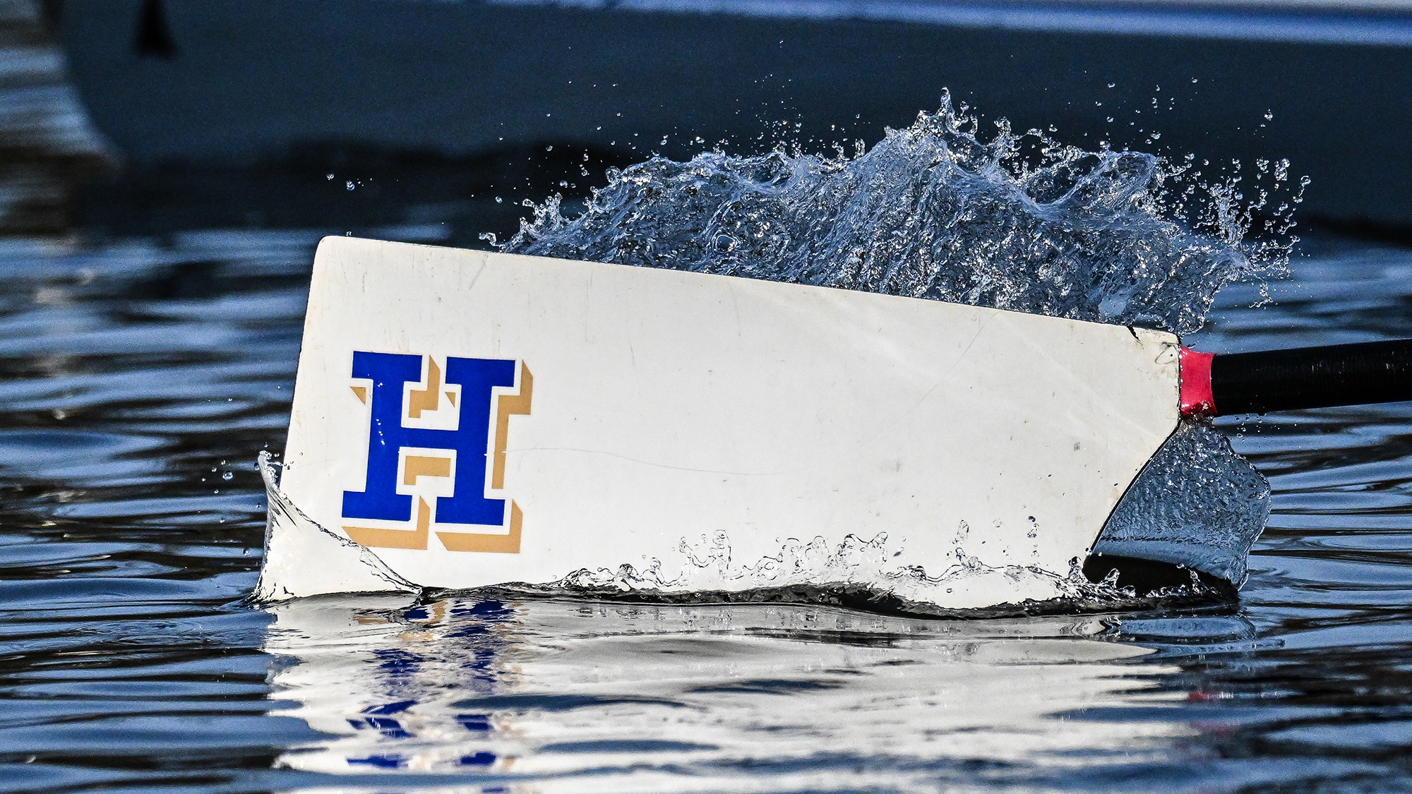 An oar splashes in the Erie Canal during rowing practice in April 2025