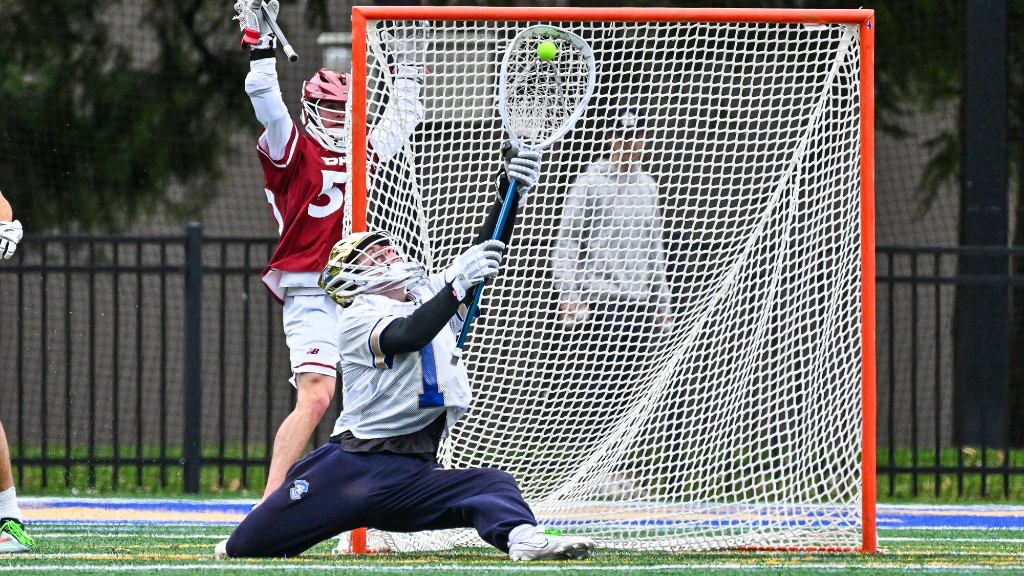 Jack Williams goes down to one knee and reaches up to save a high shot by a Bates player