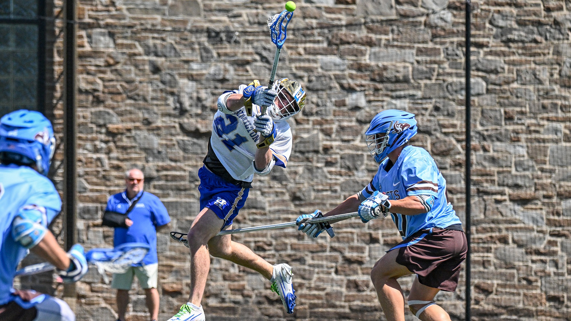 Carson Kraus leaps into the air, twists to his left and shoots in a 2026 men's lacrosse game against Tufts