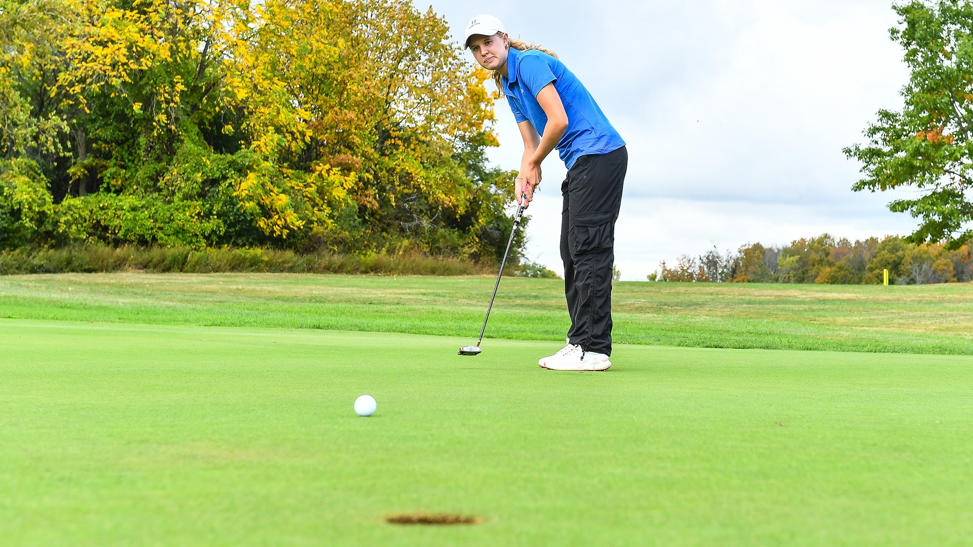 Peyton Sichol watches her putt roll towards the hole on the green during women's golf practice in September 2025