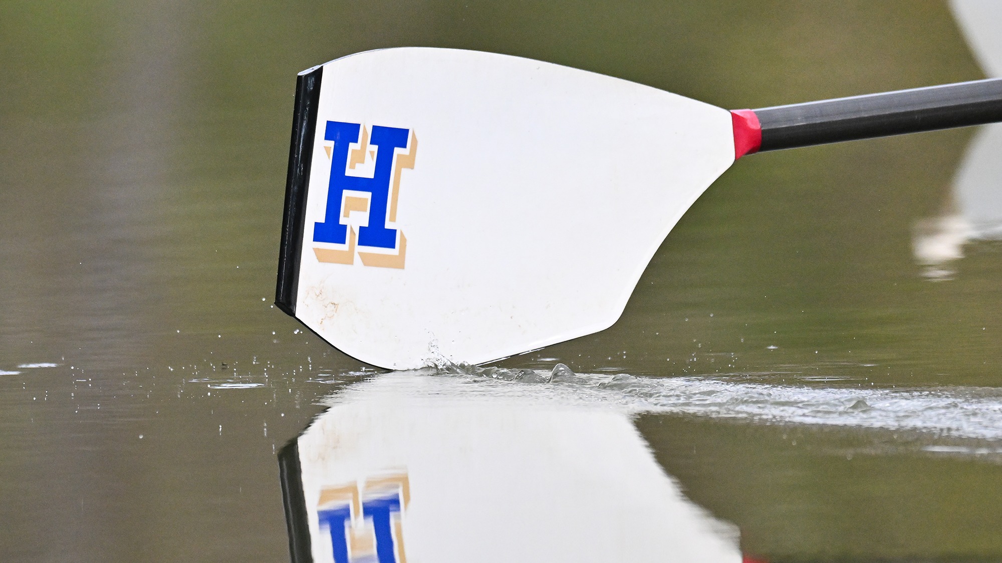 An oar splashes in the Erie Canal during women's rowing practice in April 2026