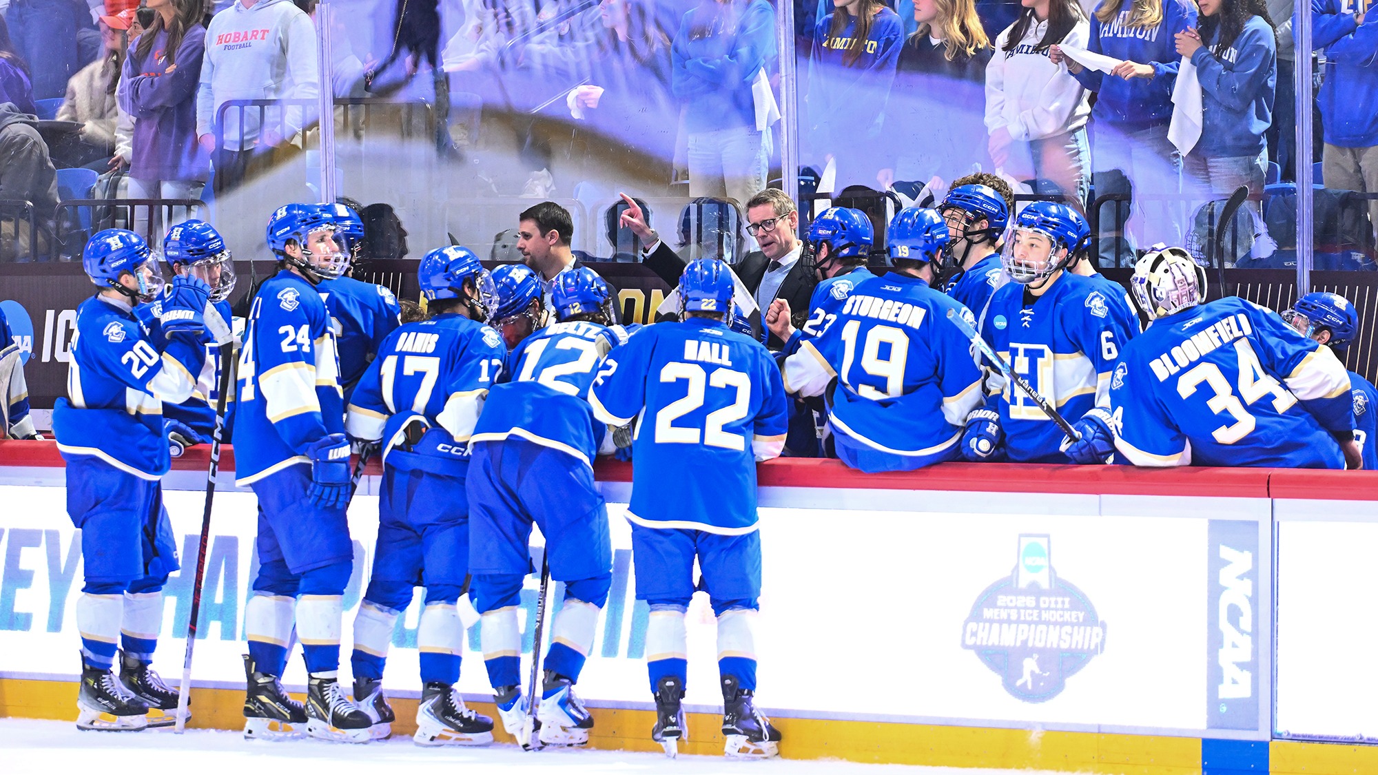 Men's Hockey team gathers in the bench area and listens to the coaching staff during overtime of the NCAA Championship final