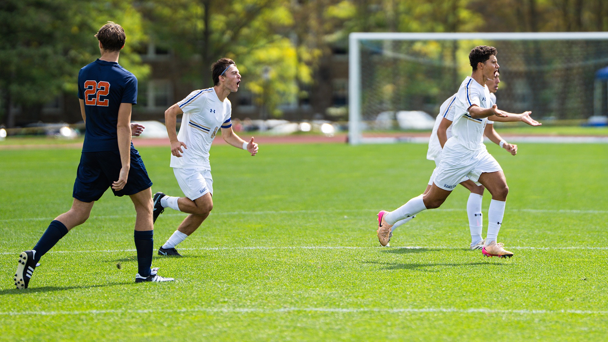 Men's Soccer players run across the field and lobby the official for a foul call against Utica