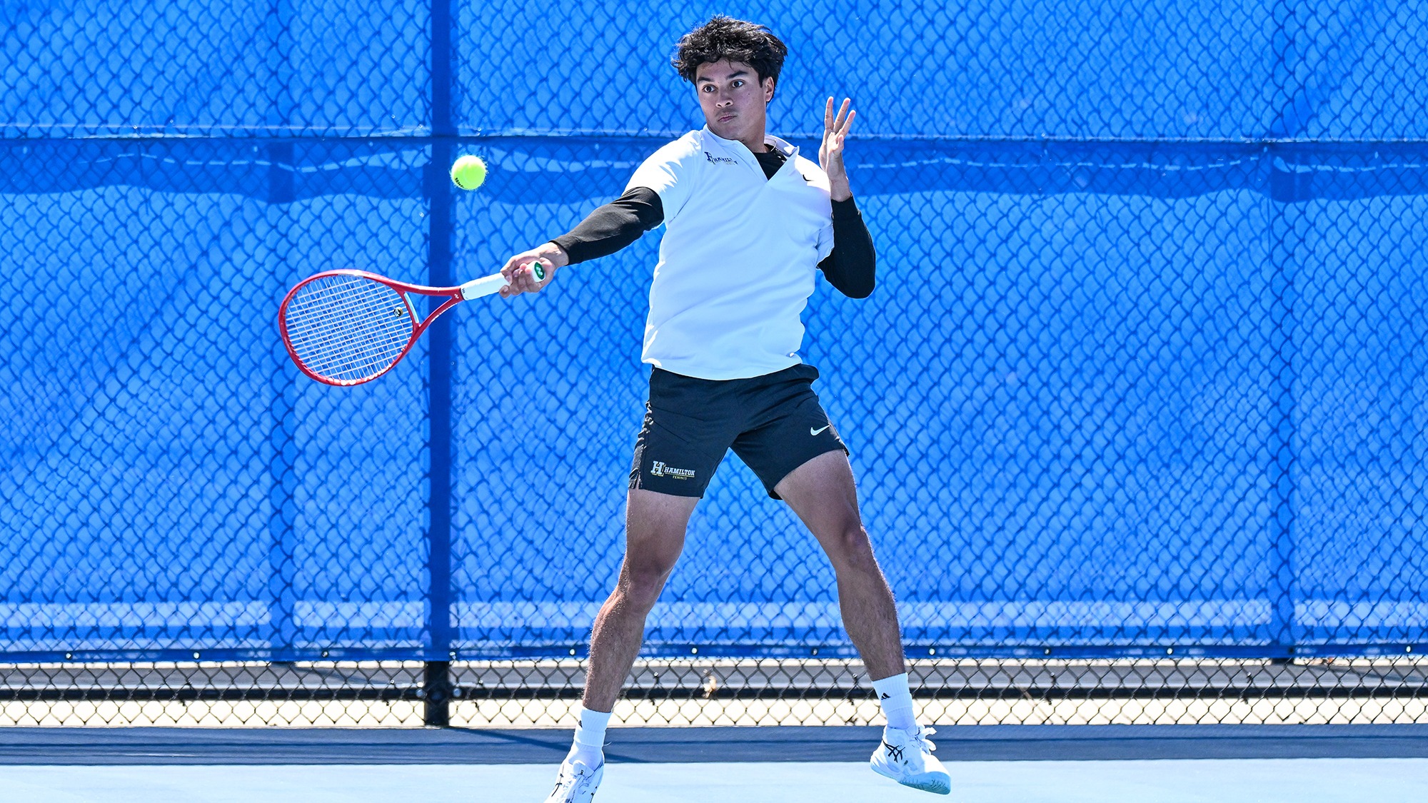 Lleyton Mendieta hits a forehand return during a men's tennis doubles match against Wesleyan