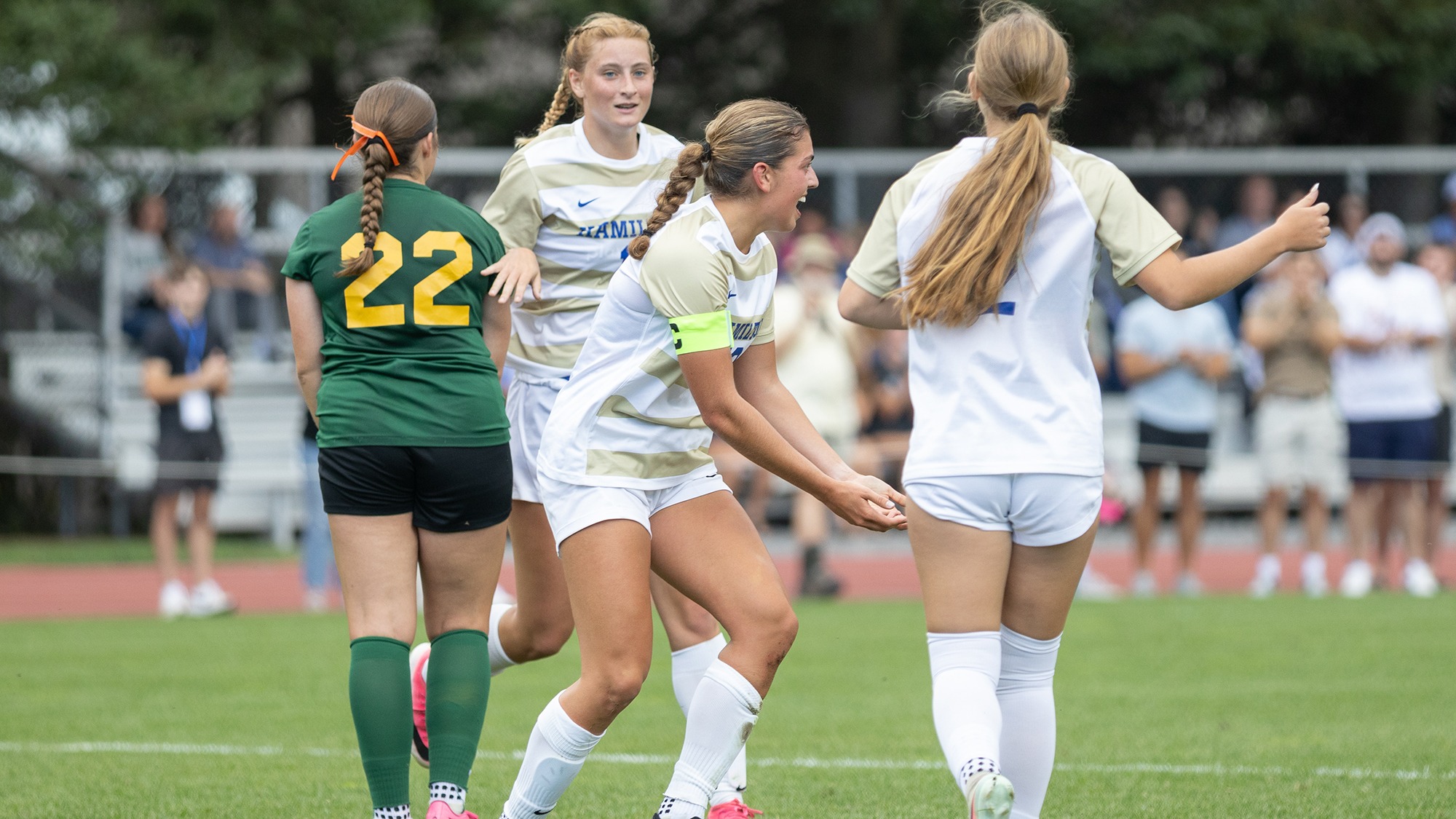 Women's Soccer players celebrate a goal against Oswego