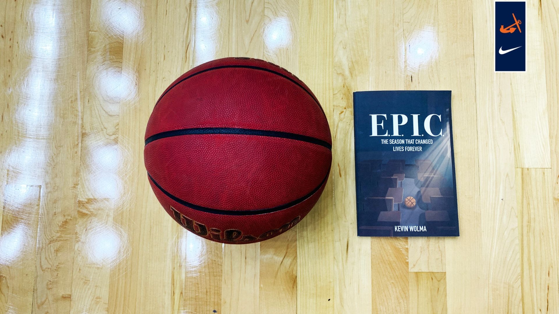A book rests on the floor next to a basketball.
