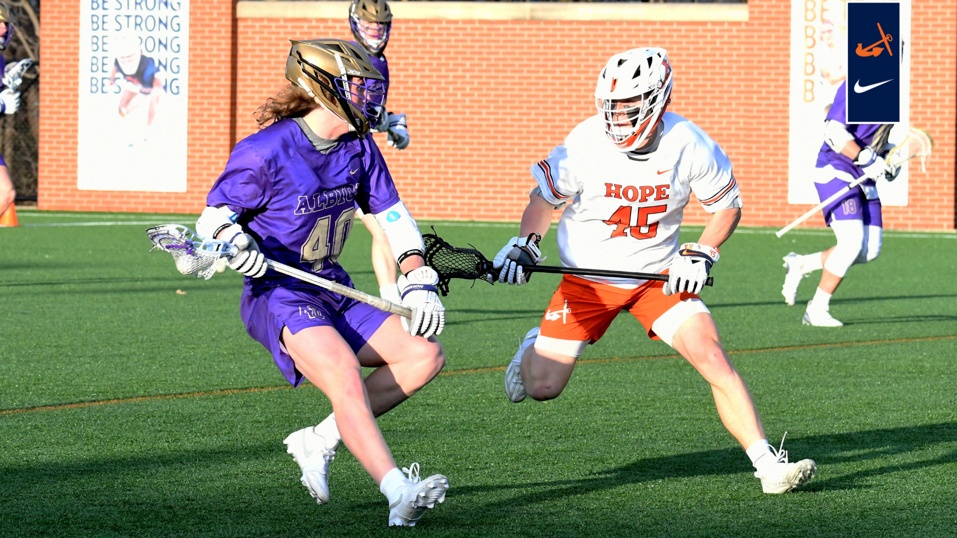 Owen Mueller defends an Albion ball carrier during a lacrosse game.