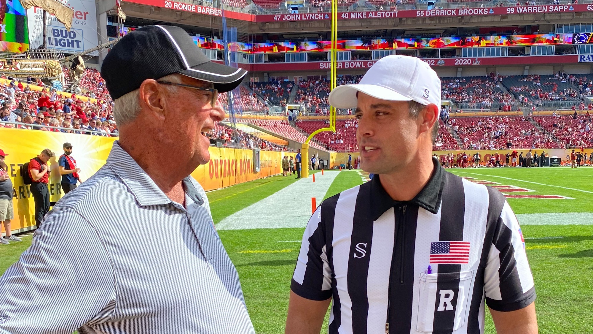 Referee Michael VanderVelde talks to his father, Mike, before the 2021 Outback Bowl.