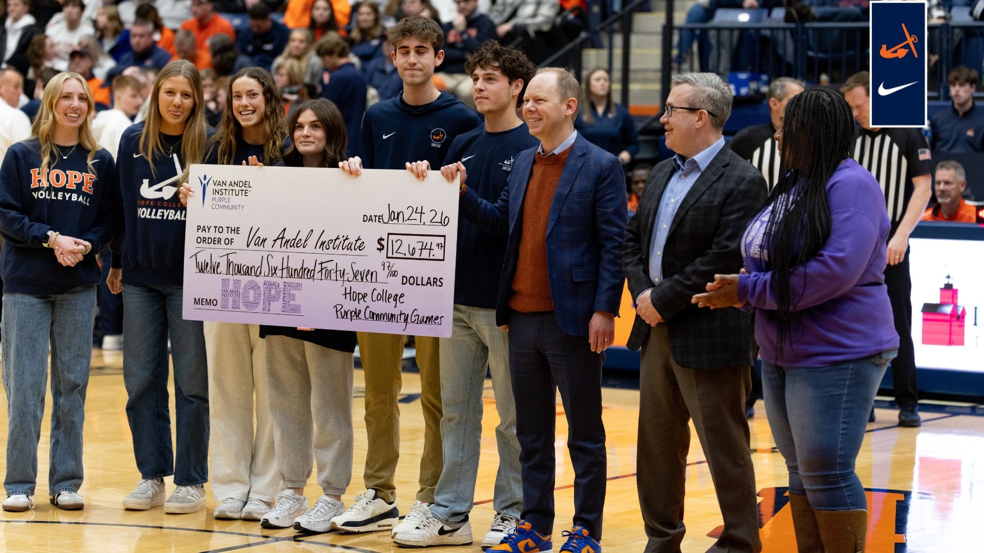 President Matthew Scogin and Hope College student-athletes present a ceremonial check to Van Andel Institute during halftime of the Hope-Calvin men's basketball game at DeVos Fieldhouse.