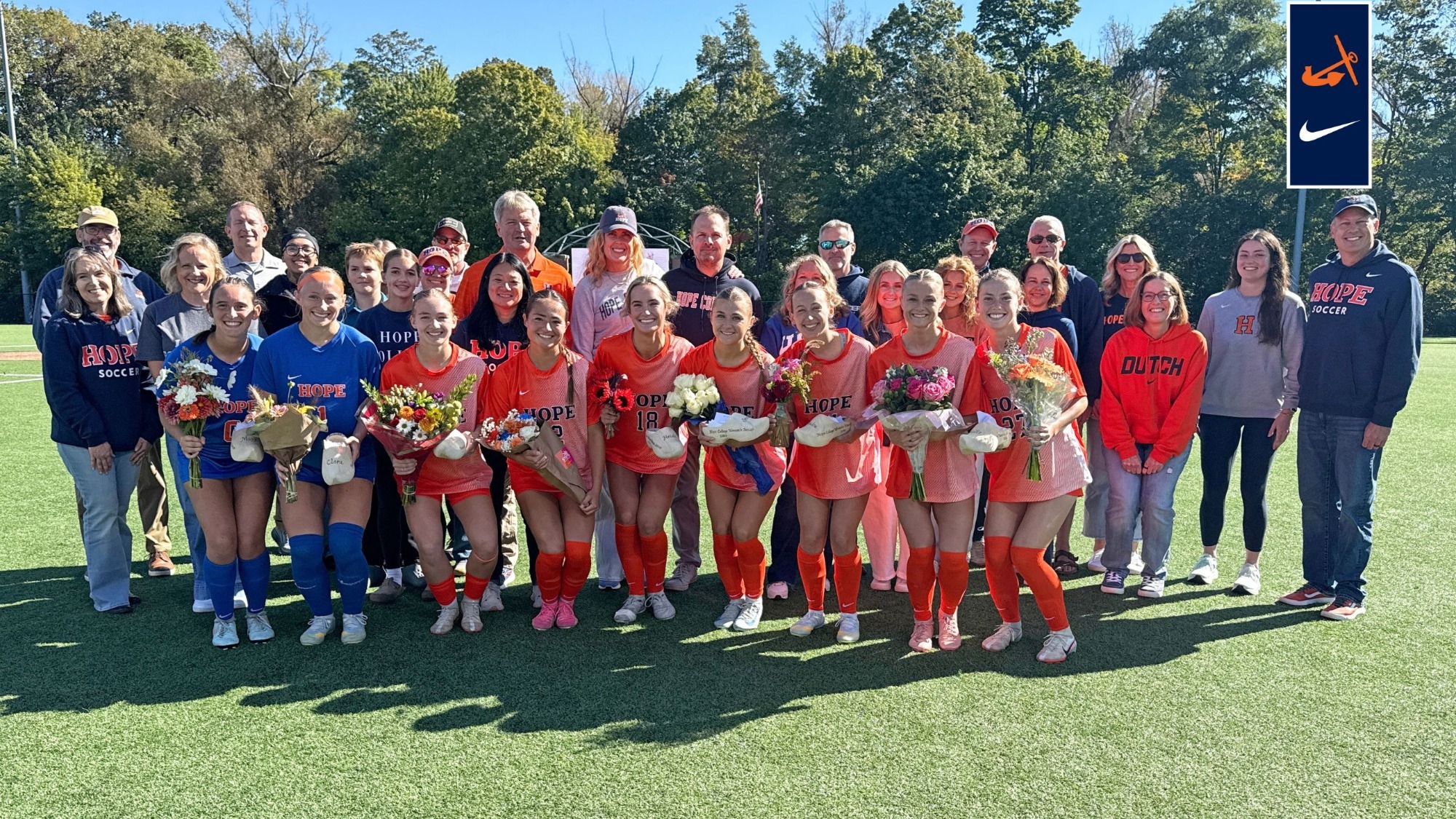 Nine Hope women's soccer seniors and their families pose for a picture at Van Andel Soccer Stadium.
