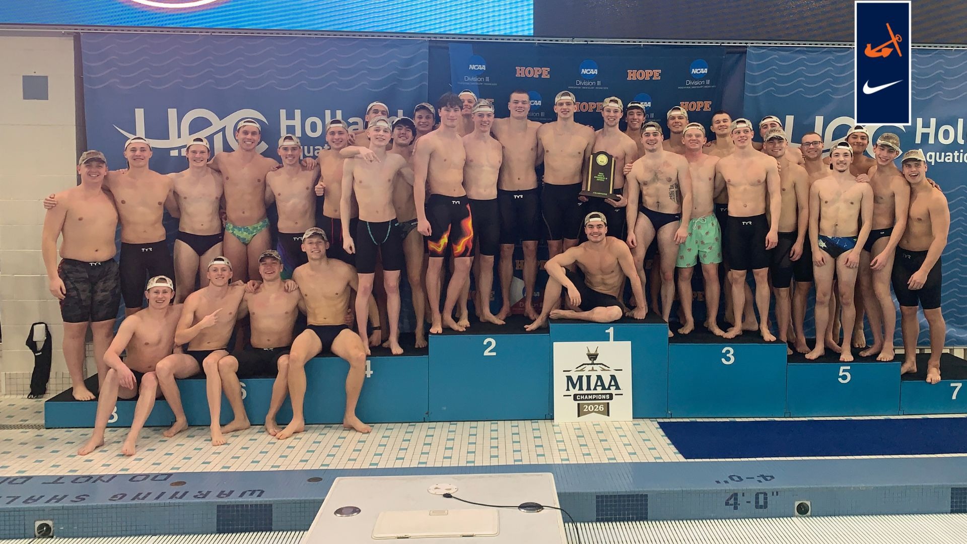 Hope College men's swimmers and divers hold the MIAA championship trophy on the pool deck.