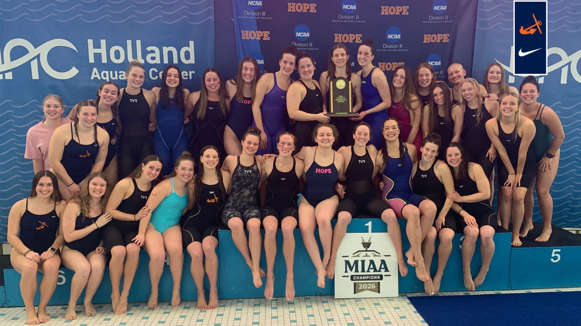 The Hope College women's swimming and diving team hold the MIAA championship trophy.