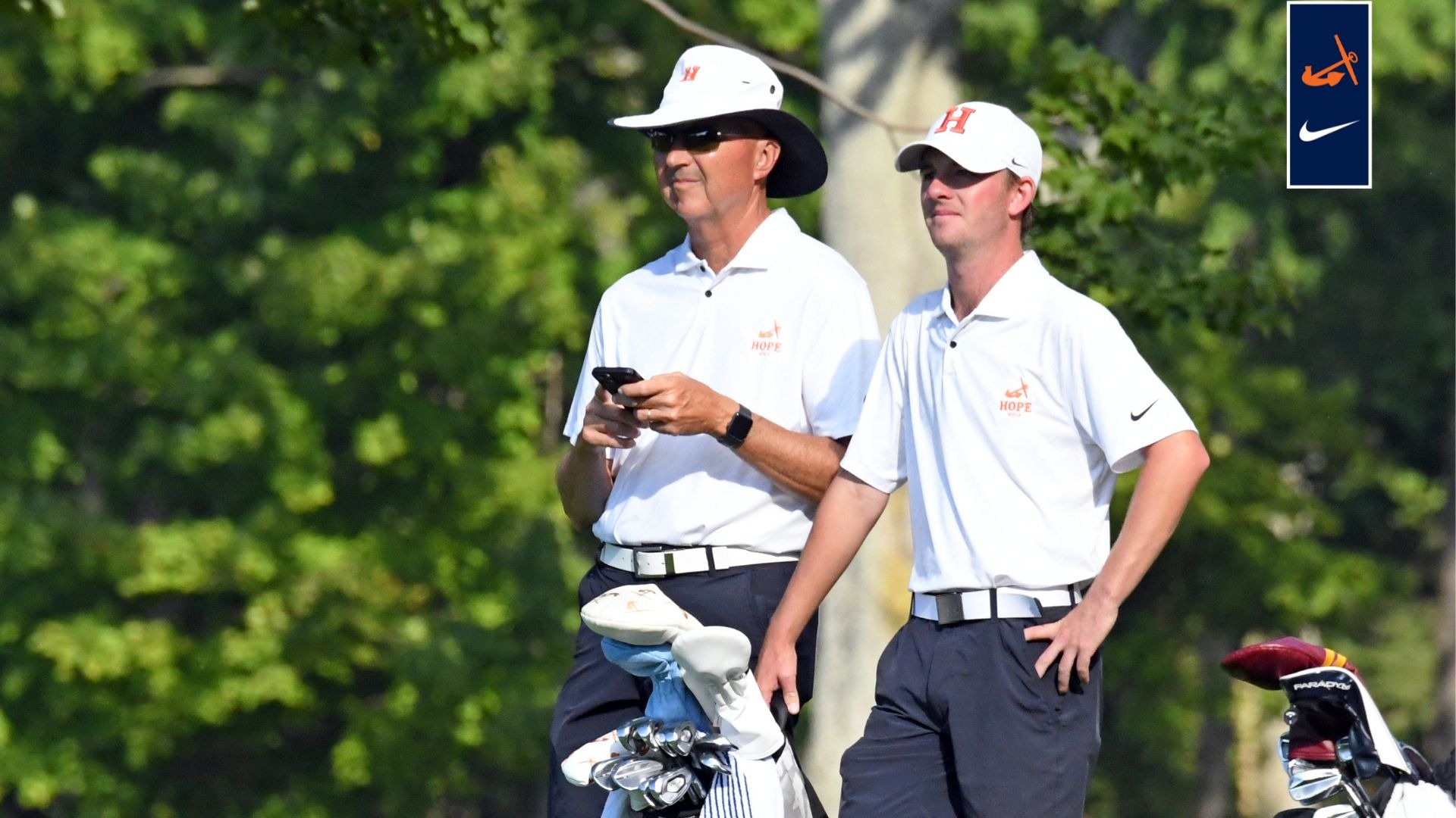 Scott Lokers stands at a tee box with Hope College golfer Will Webb.
