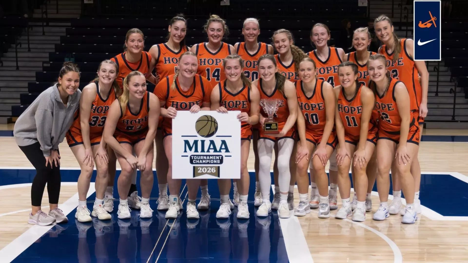 The Hope College women's basketball team holds the MIAA Tournament trophy.