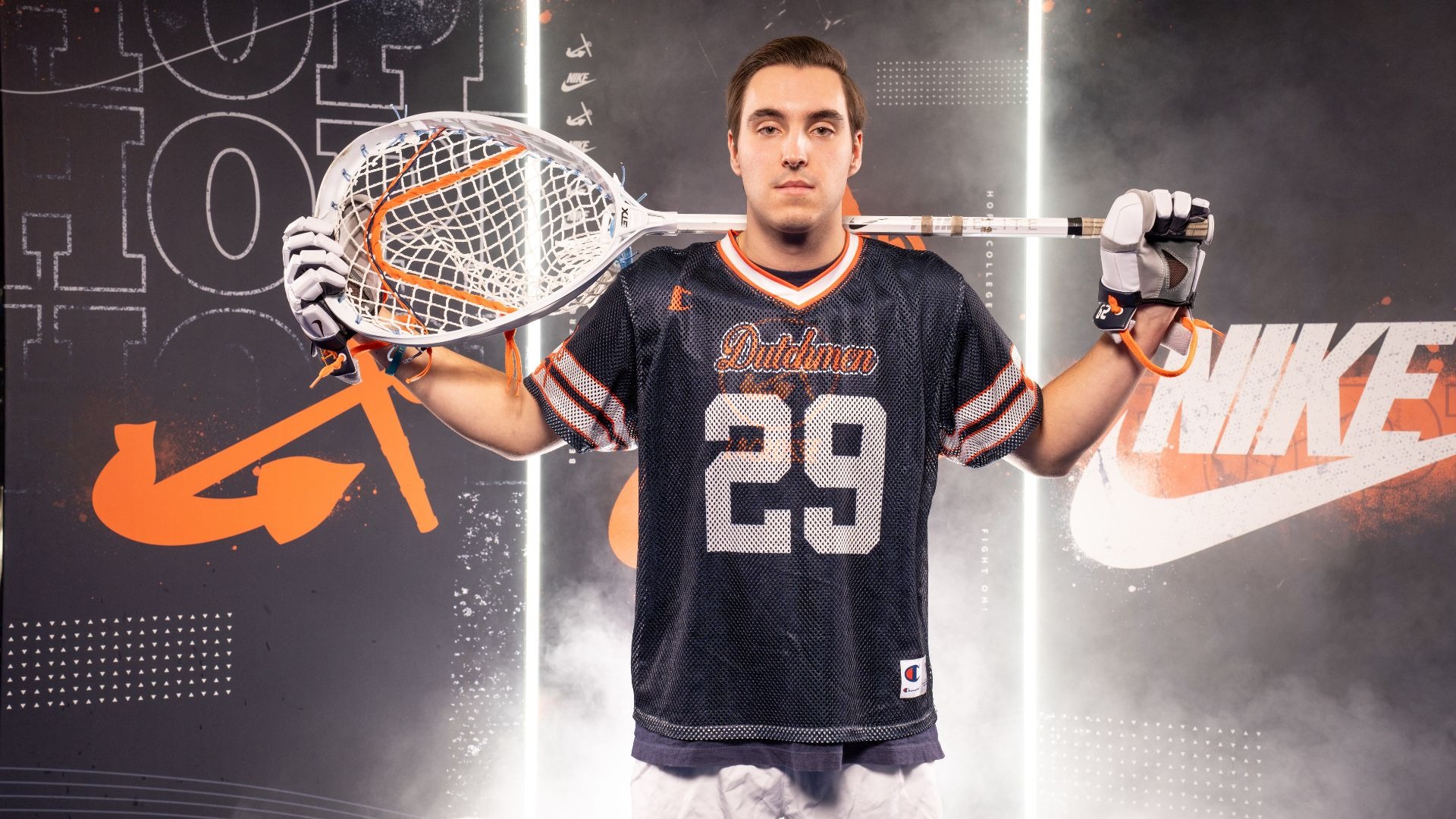 Goalie Jack Balmforth holds a lacrosse stick on his shoulders.