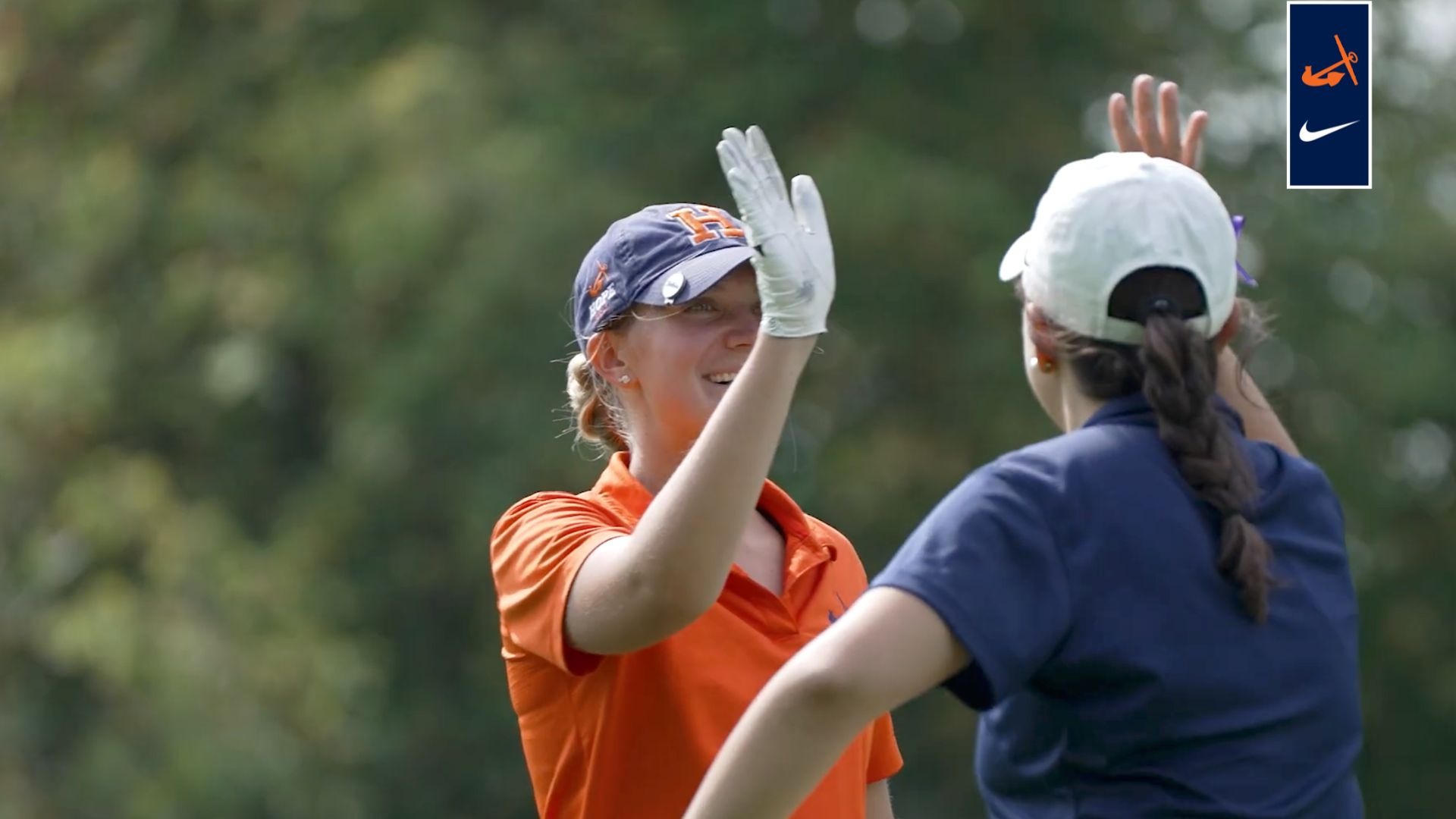 Head women's golf coach Megan Radaz high-fives a Hope College golfer.