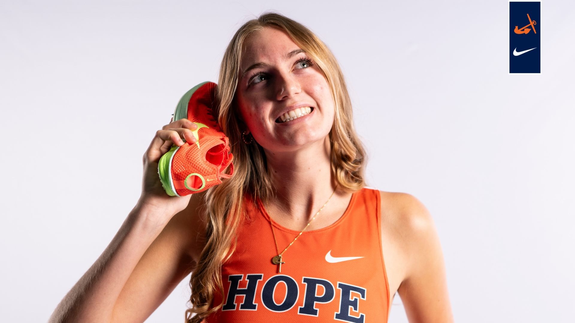 Erin Stuk holds running shoes to her ear.