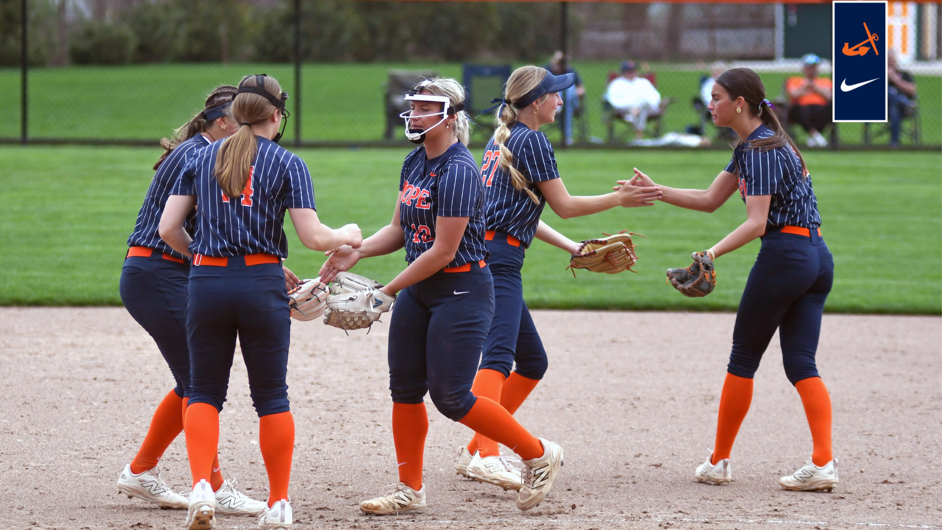 The softball team slaps hands before an inning