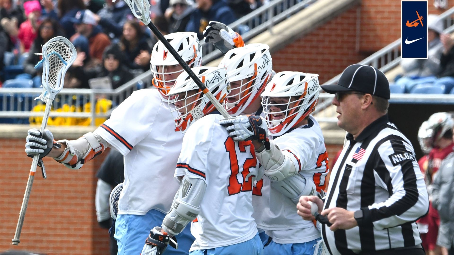 Four Hope men's lacrosse teammates huddle to celebrate a goal.