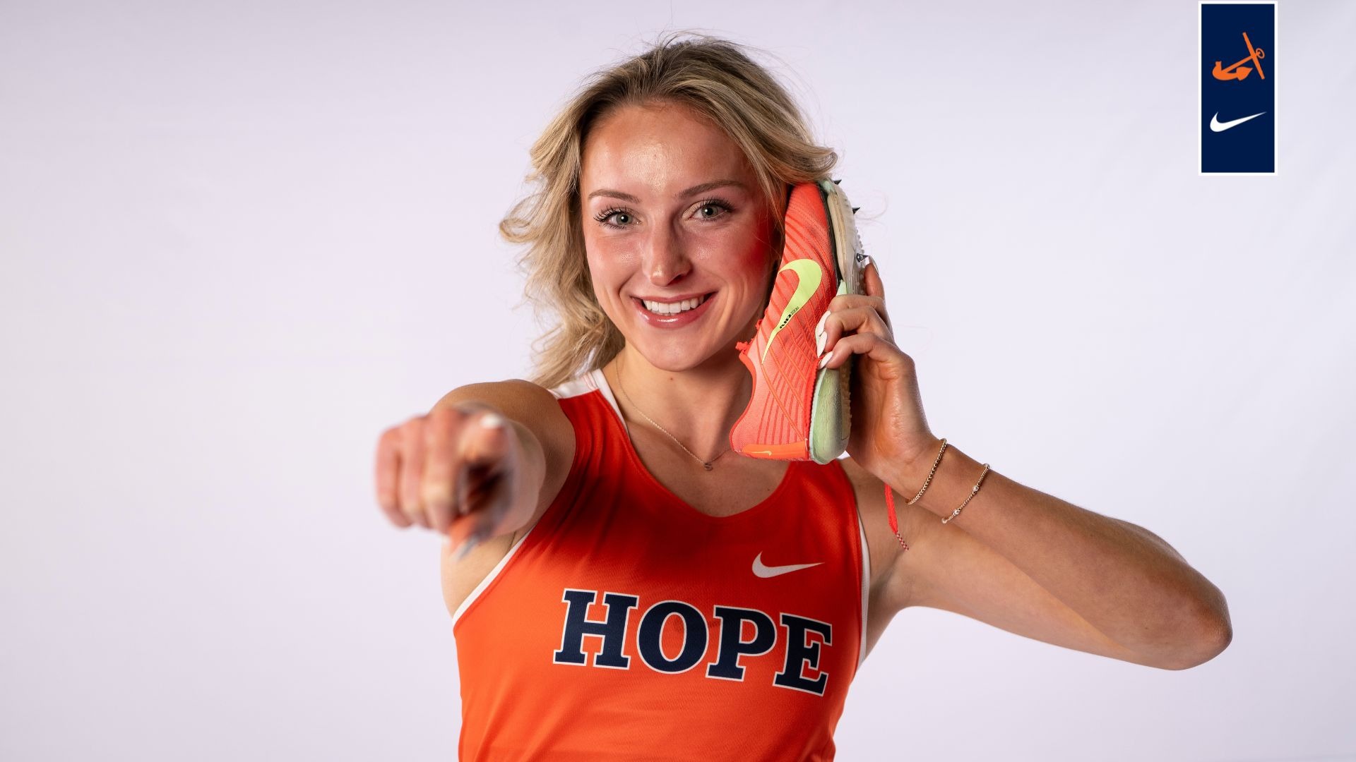 Sara Schermerhorn holds a running shoe to her ear.