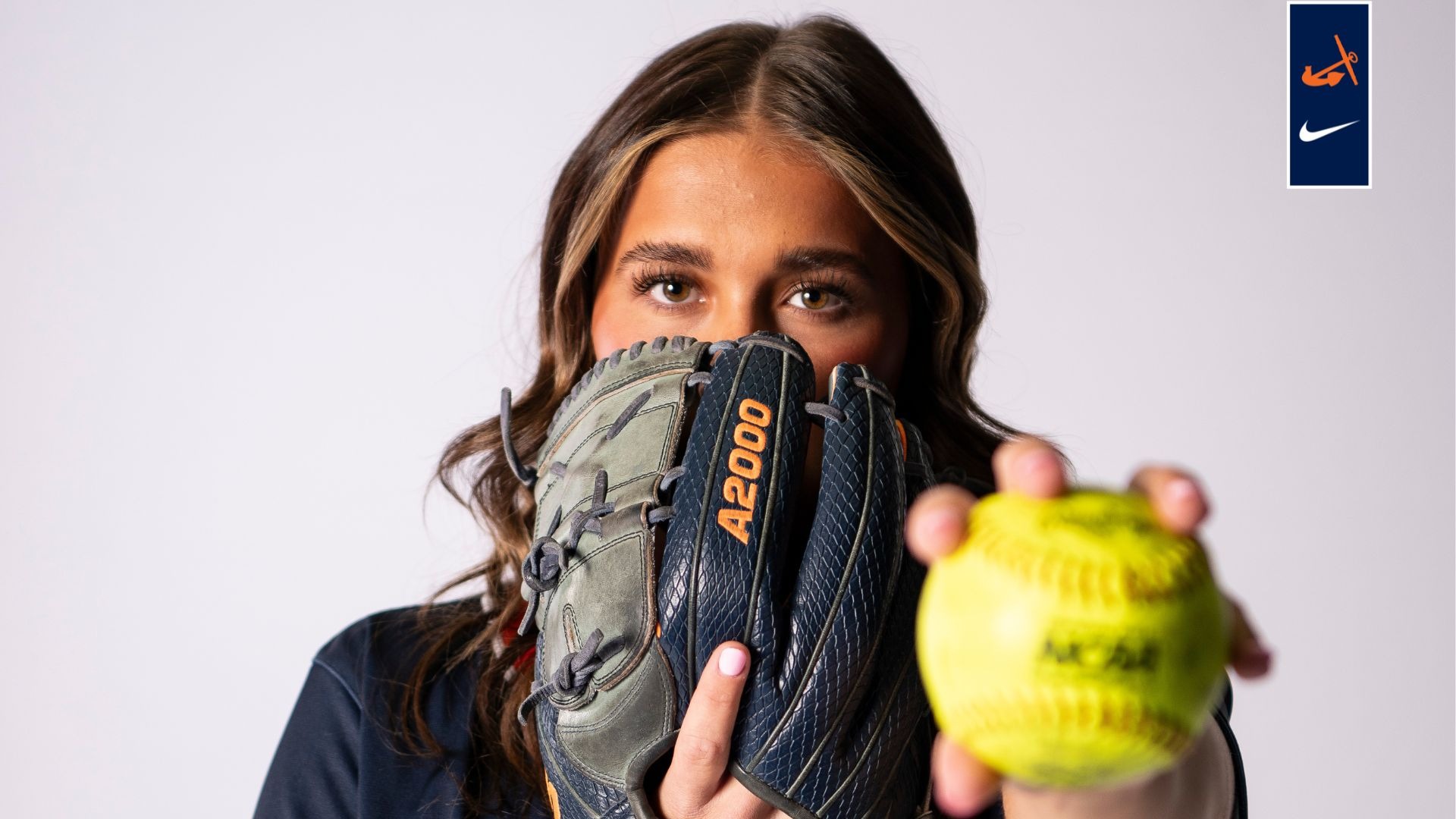 Hailey Mellec holds a softball in front of her.