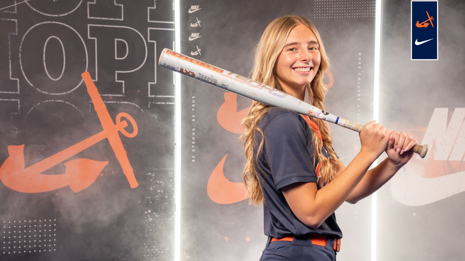 Macy Verbeek holds a softball bat on her shoulder.