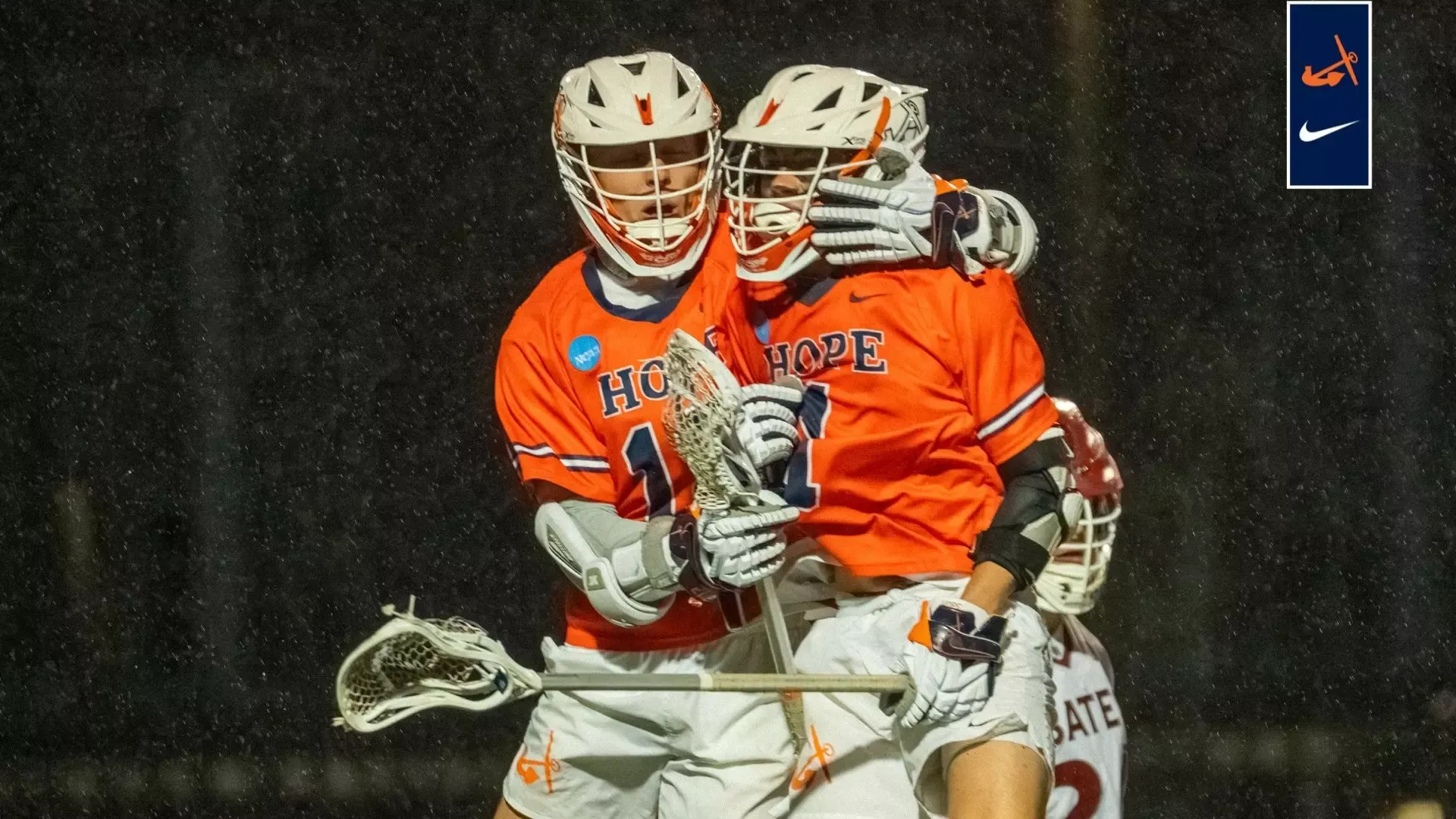 Two Hope College men's lacrosse teammates huddle to celebrate a goal.
