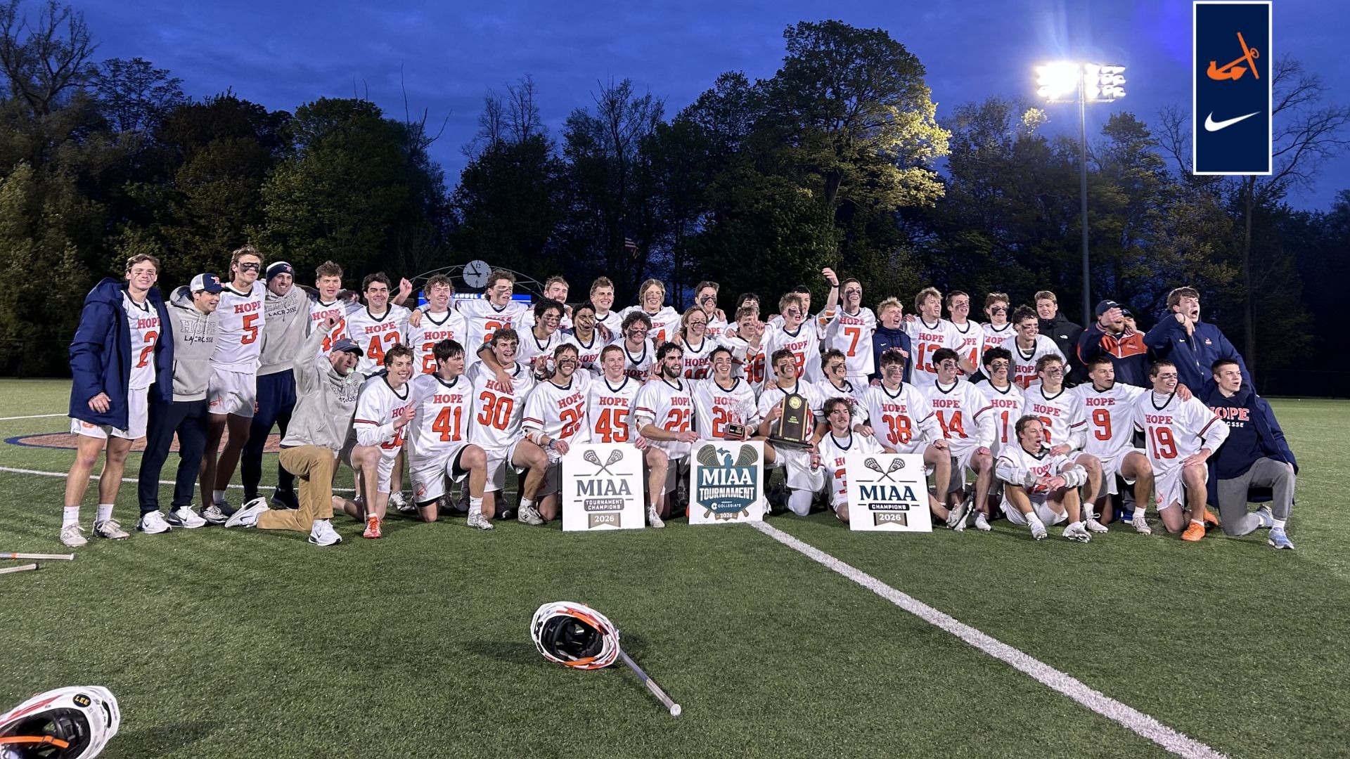 The Hope College men's lacrosse team holds the MIAA Tournament and regular-season trophies.