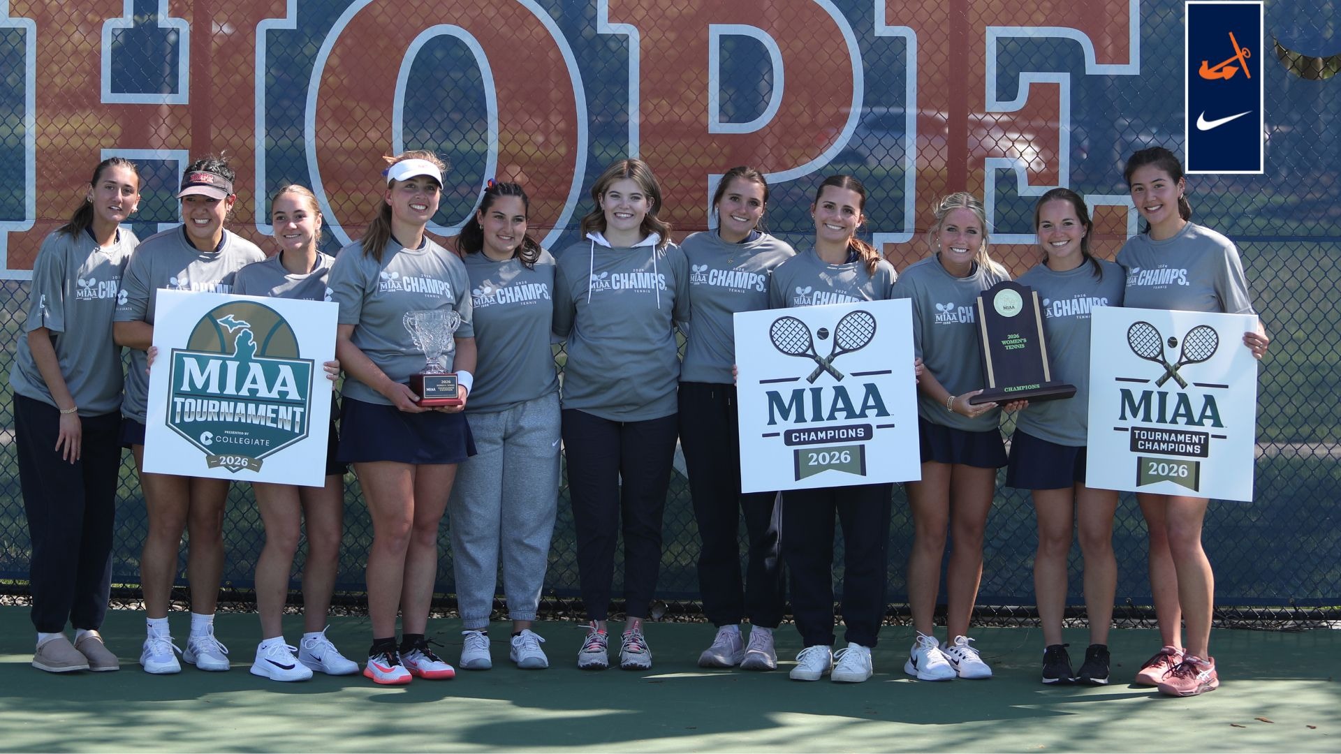 The Hope College women's tennis team holds the MIAA Tournament trophy.